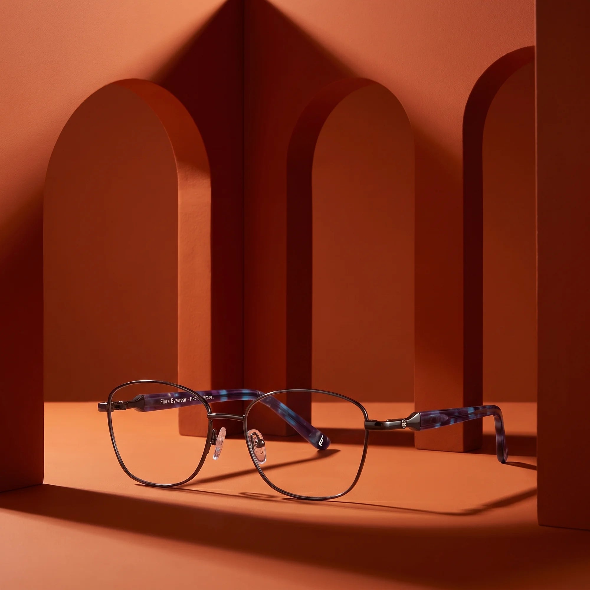 Fiore 2208 eyeglasses in gun blue – still life among monochrome burnt orange arches