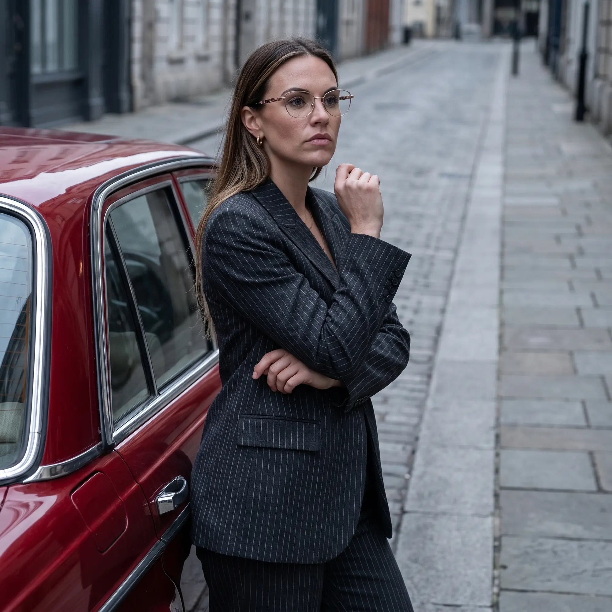 Fiore 2208 eyeglasses in brown tortoiseshell, worn by a model – campaign portrait, pinstripe suit beside a classic red car