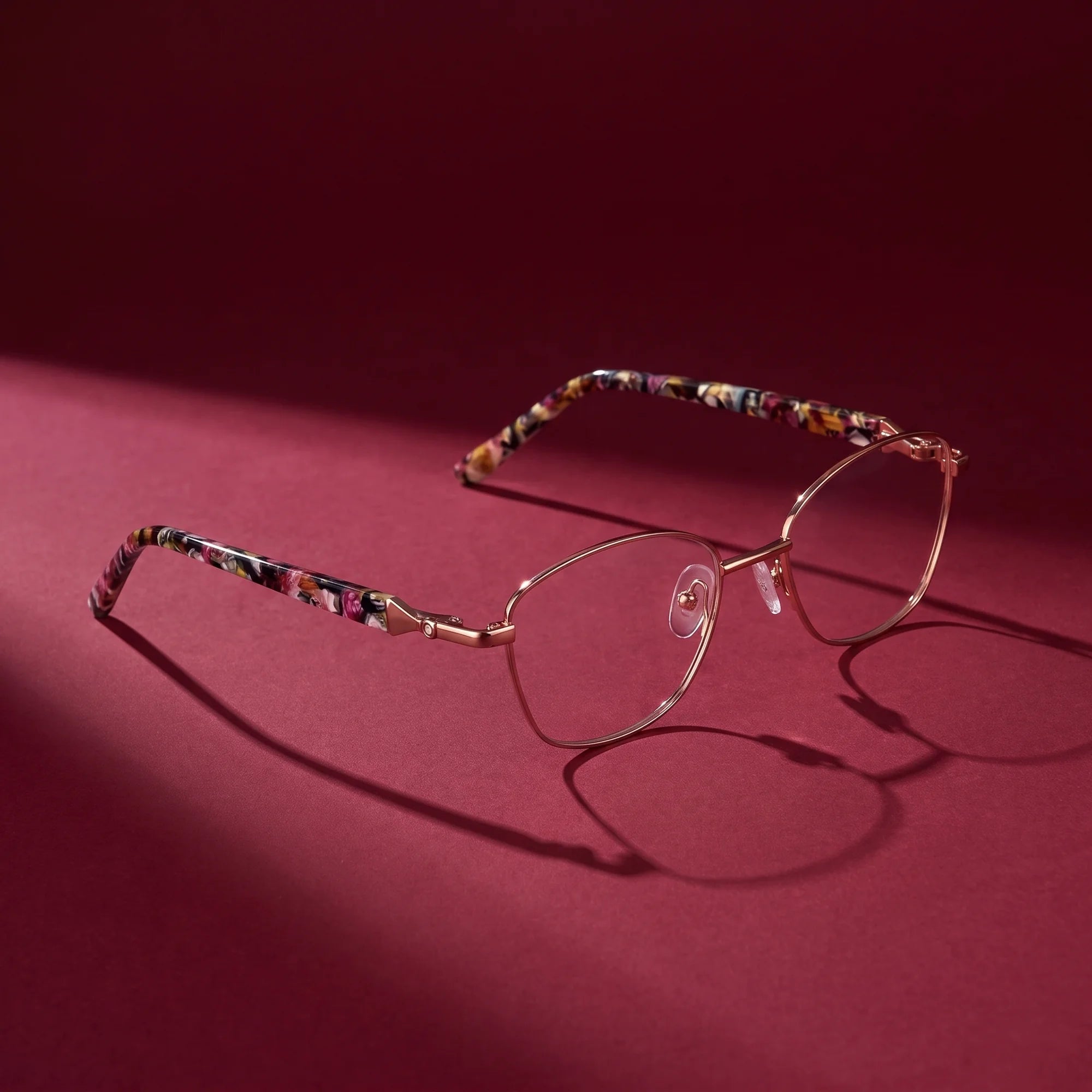 Fiore 2208 eyeglasses in brown tortoiseshell – editorial still life on a saturated burgundy set