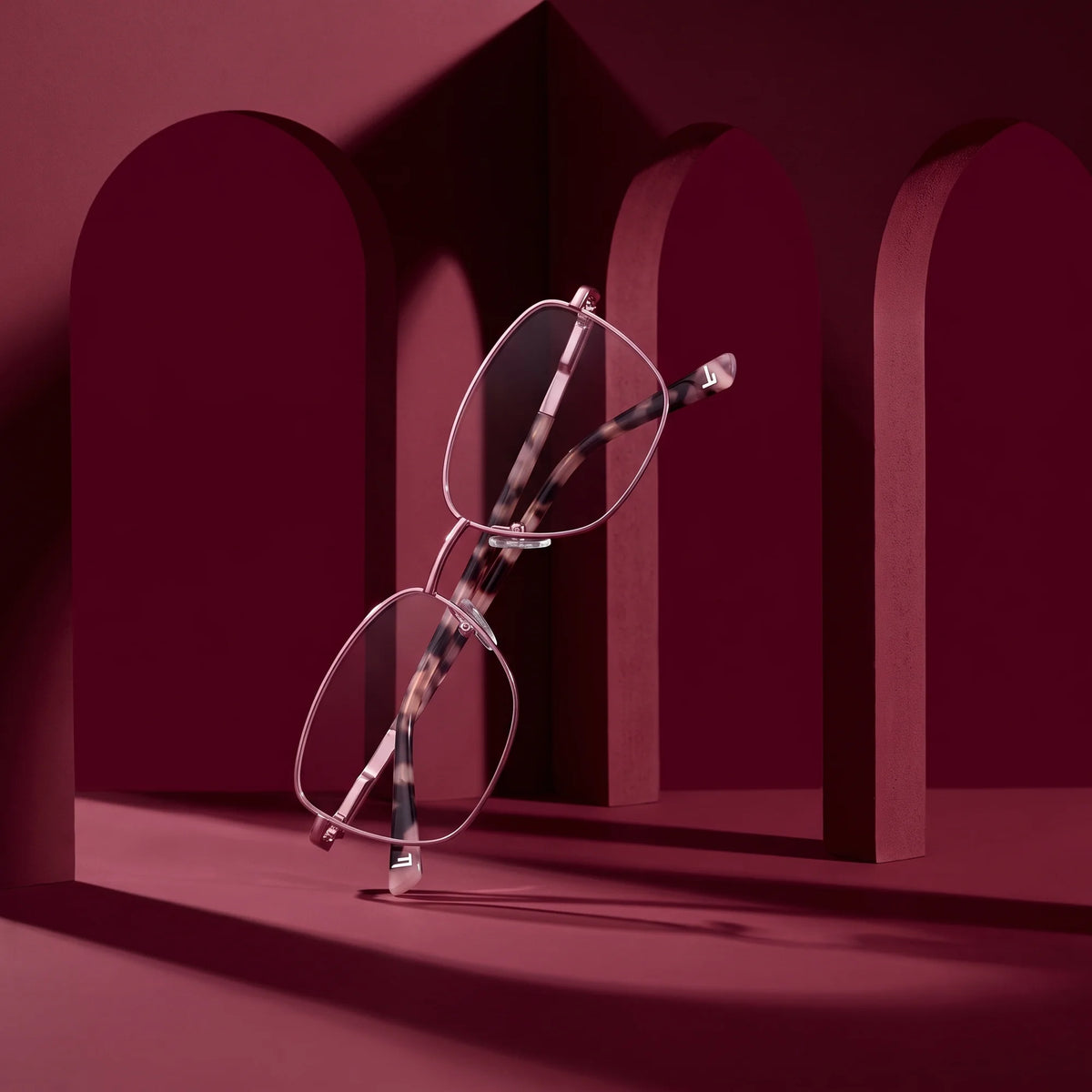 Fiore 2210 eyeglasses in pink – still life among monochrome burgundy arches