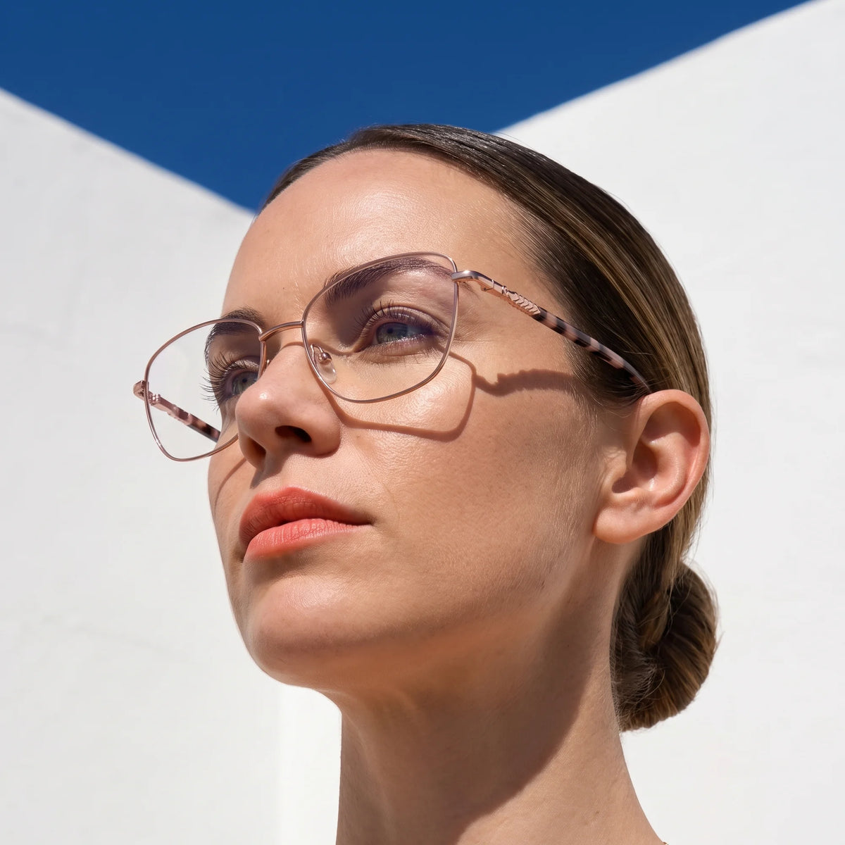 Fiore 2210 eyeglasses in pink, worn by a model – campaign portrait, sunlit Balearic whitewash and deep blue sky