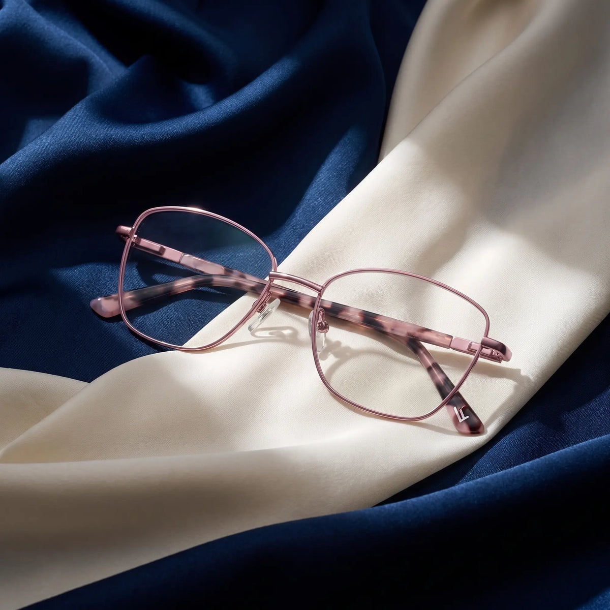 Fiore 2210 eyeglasses in pink – resting on draped midnight blue and ivory silk