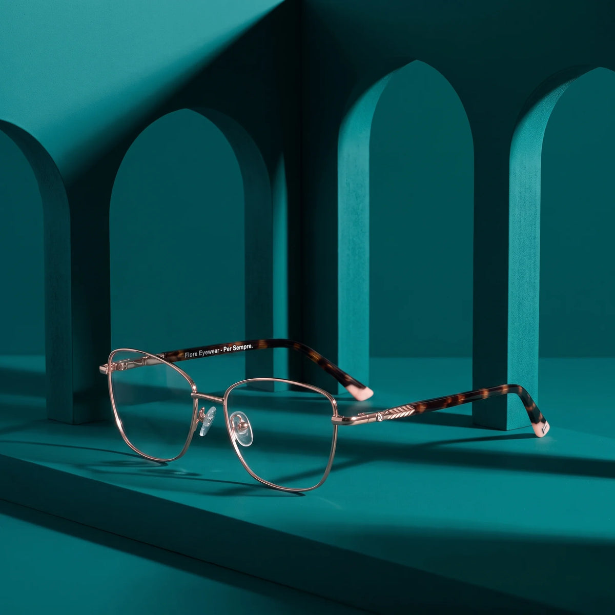 Fiore 2210 eyeglasses in gold pink – still life among monochrome teal arches