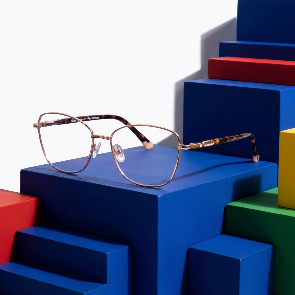 Fiore 2210 eyeglasses in gold pink – on bold primary color-block steps