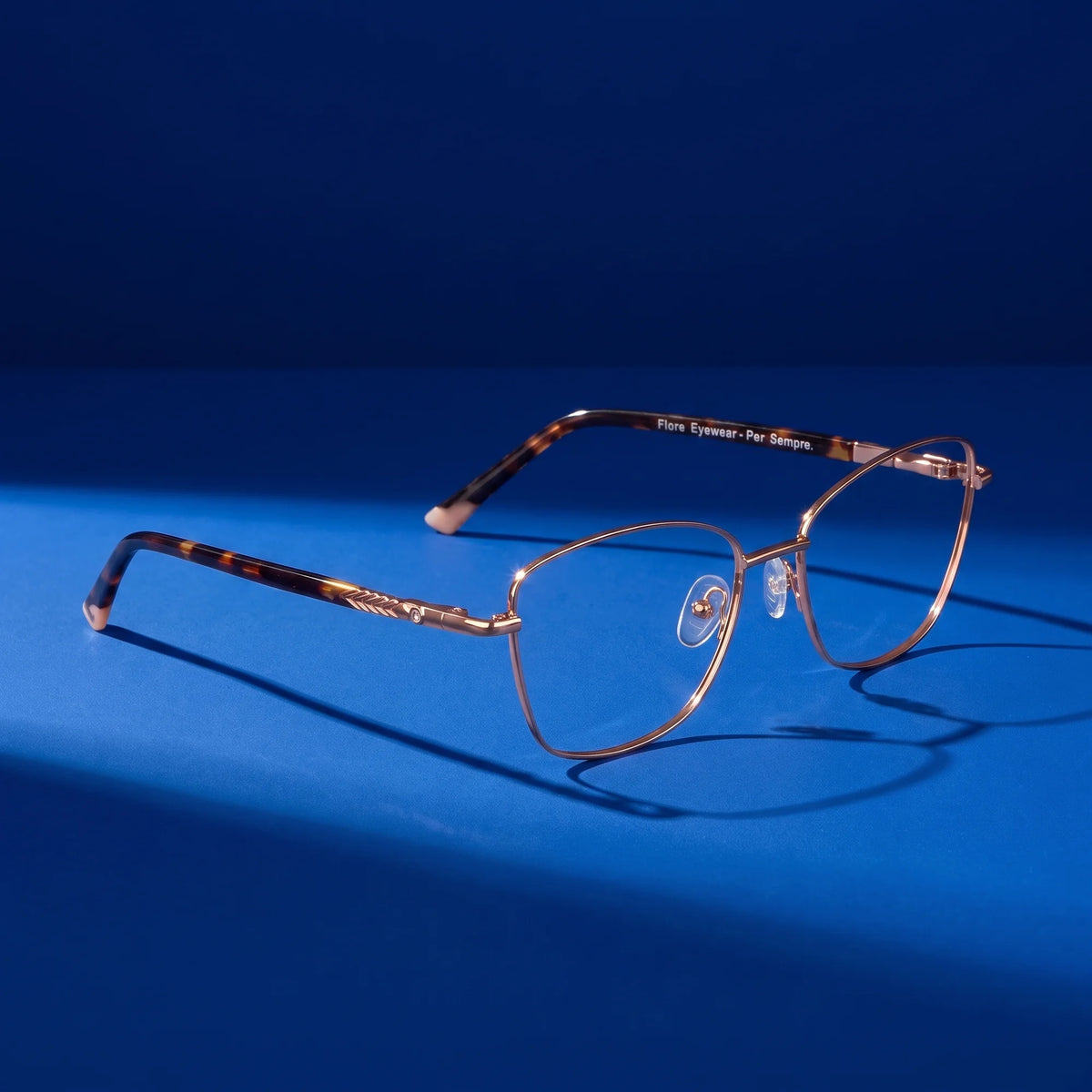 Fiore 2210 eyeglasses in gold pink – still life on a seamless cobalt studio backdrop