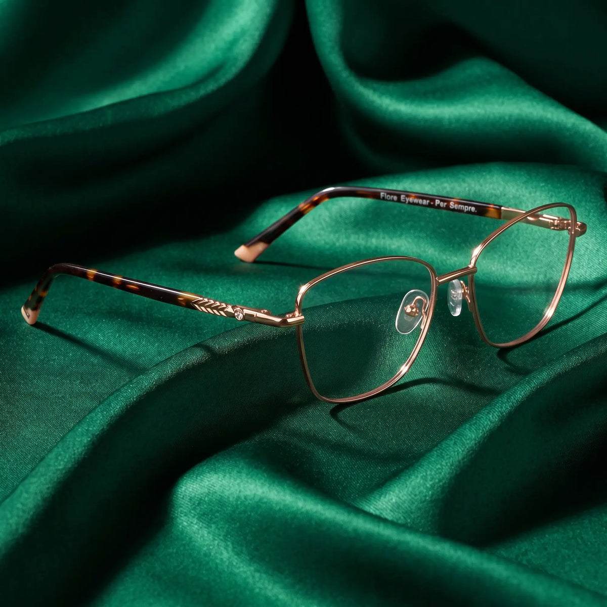 Fiore 2210 eyeglasses in gold pink – nested in flowing emerald silk