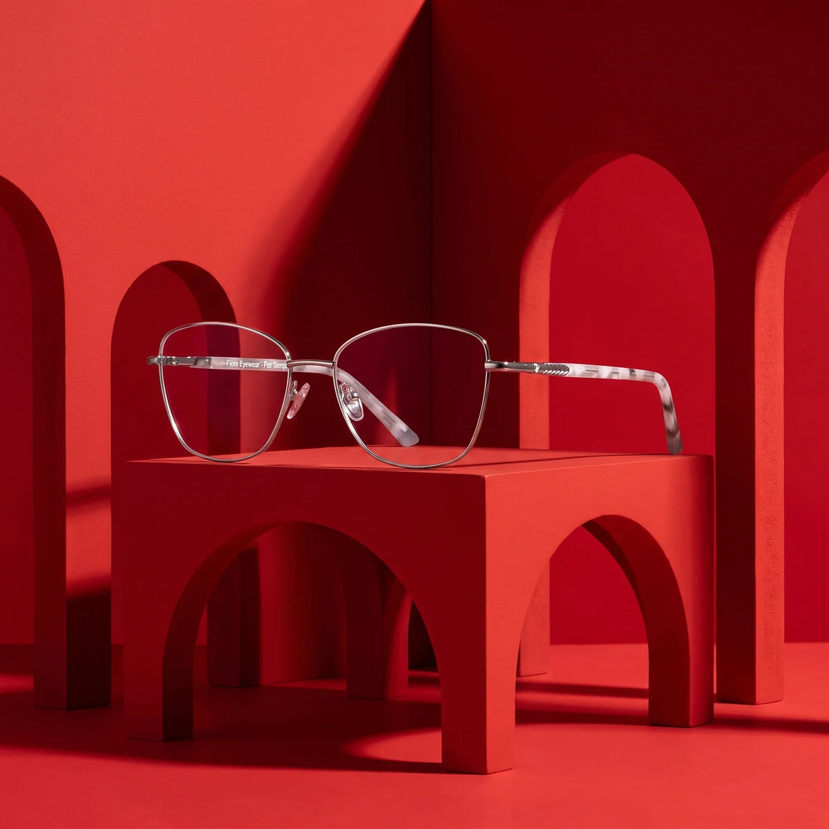 Fiore 2210 eyeglasses in silver black – staged on a sculptural vivid red architecture set