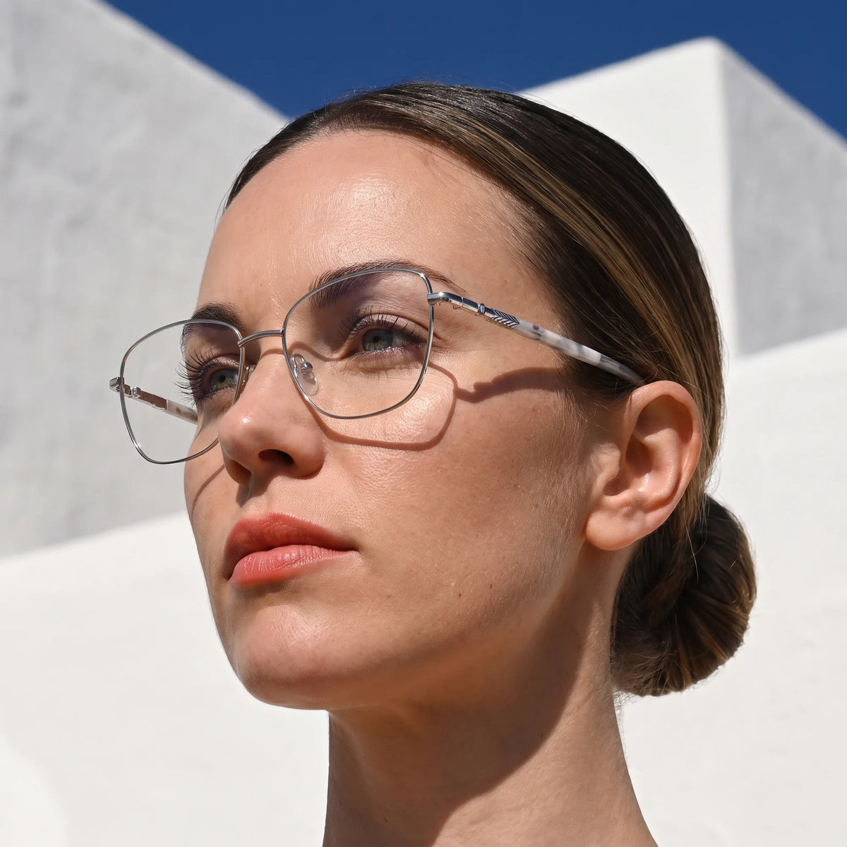 Fiore 2210 eyeglasses in silver black, worn by a model – campaign portrait, sunlit Balearic whitewash and deep blue sky