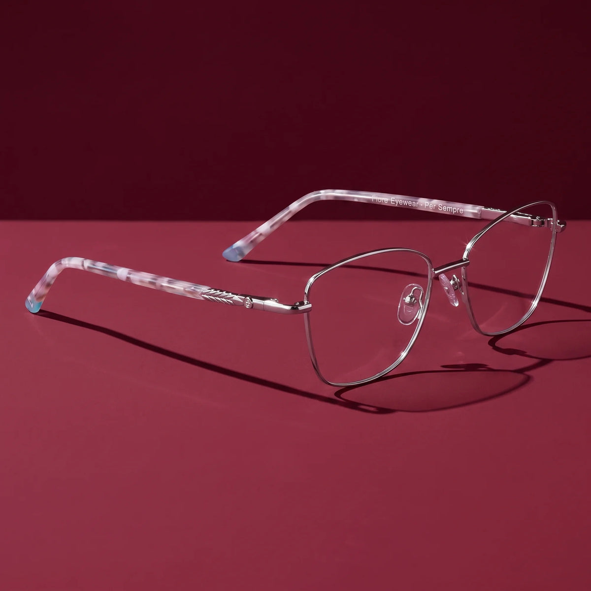 Fiore 2210 eyeglasses in silver black – editorial still life on a saturated burgundy set