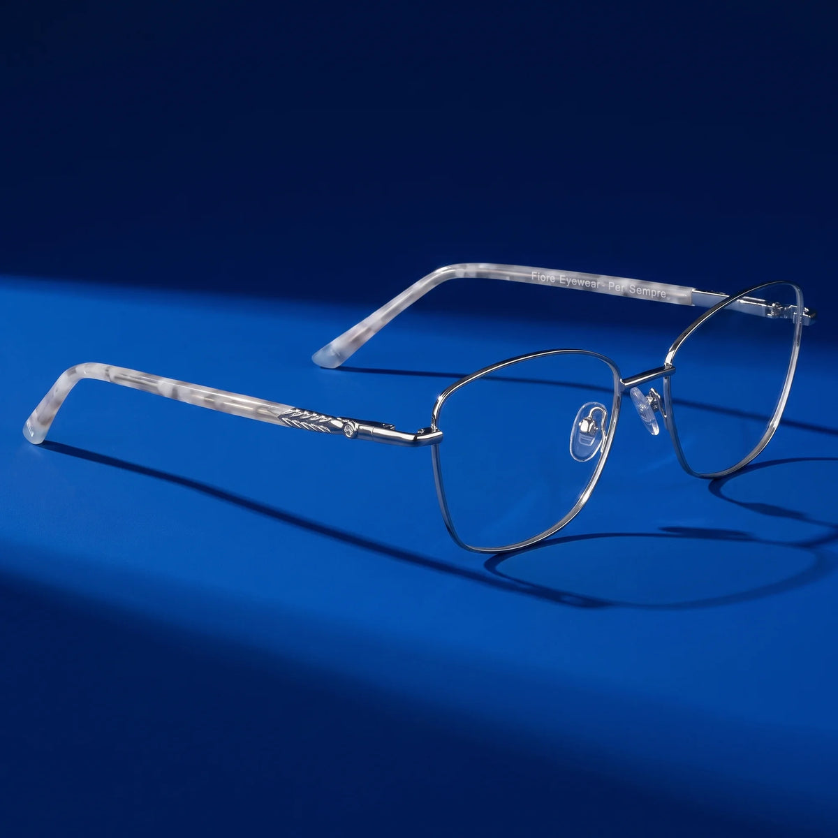 Fiore 2210 eyeglasses in silver black – hero still life against a deep cobalt backdrop