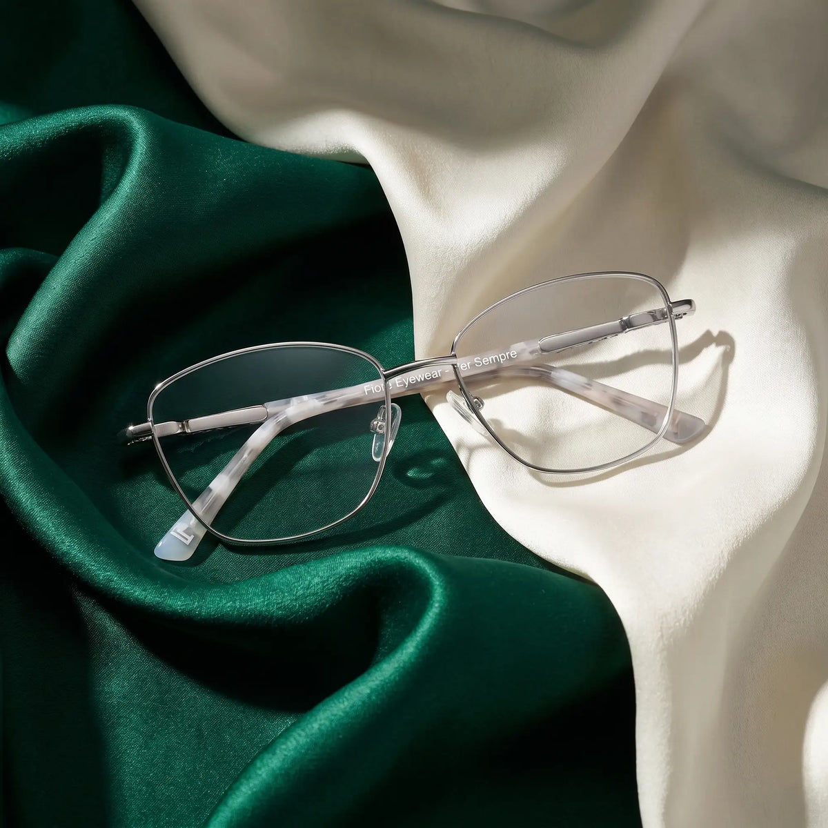 Fiore 2210 eyeglasses in silver black – resting on draped emerald and ivory silk