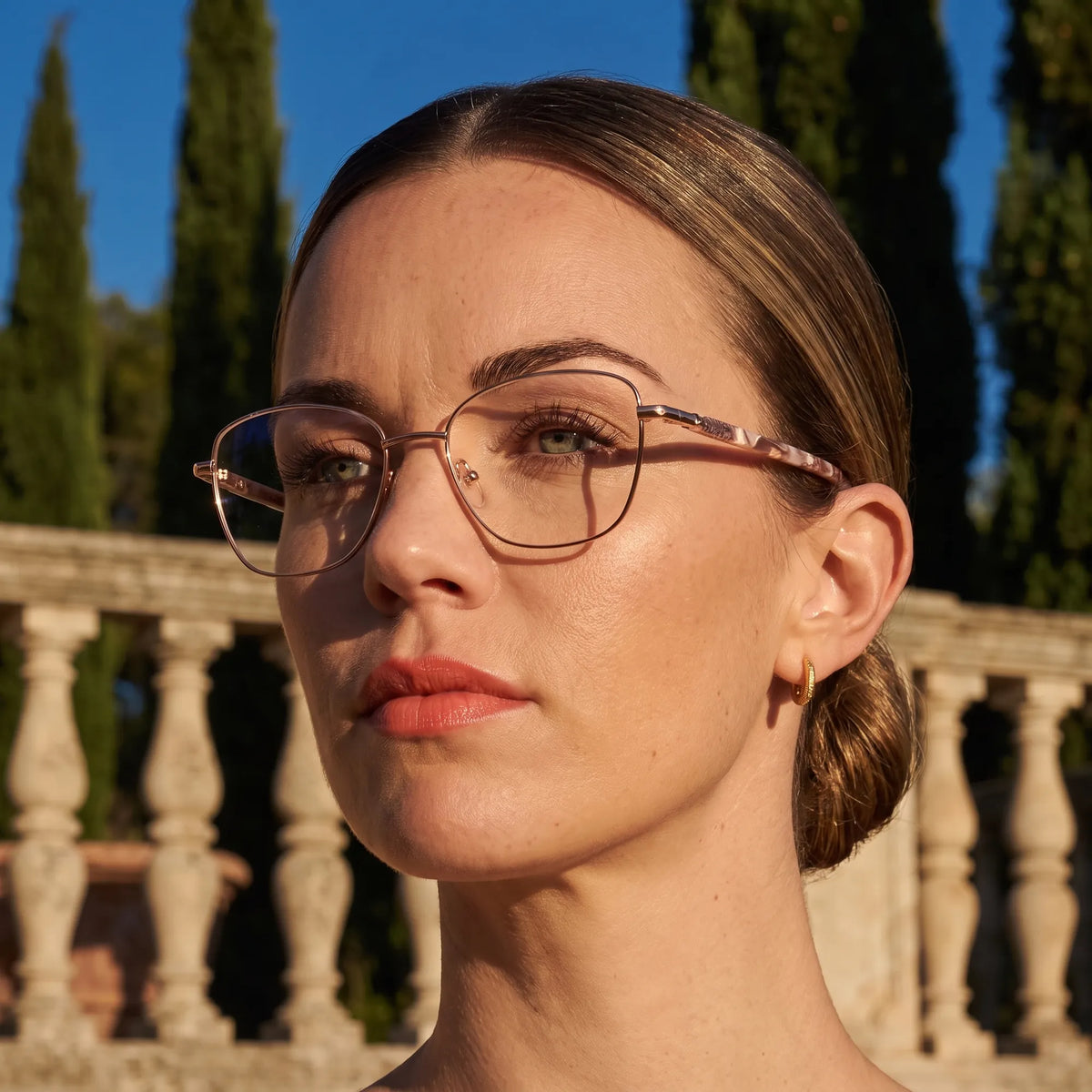 Fiore 2210 eyeglasses in gold brown, worn by a model – campaign portrait, golden-hour Italian villa terrace