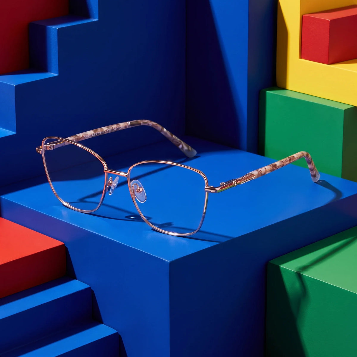Fiore 2210 eyeglasses in gold brown – on bold primary color-block steps