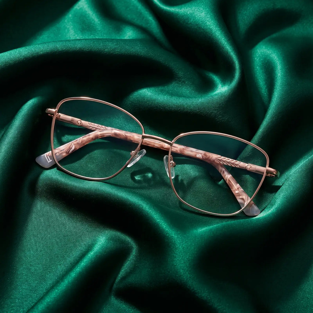 Fiore 2210 eyeglasses in gold brown – nested in flowing emerald silk