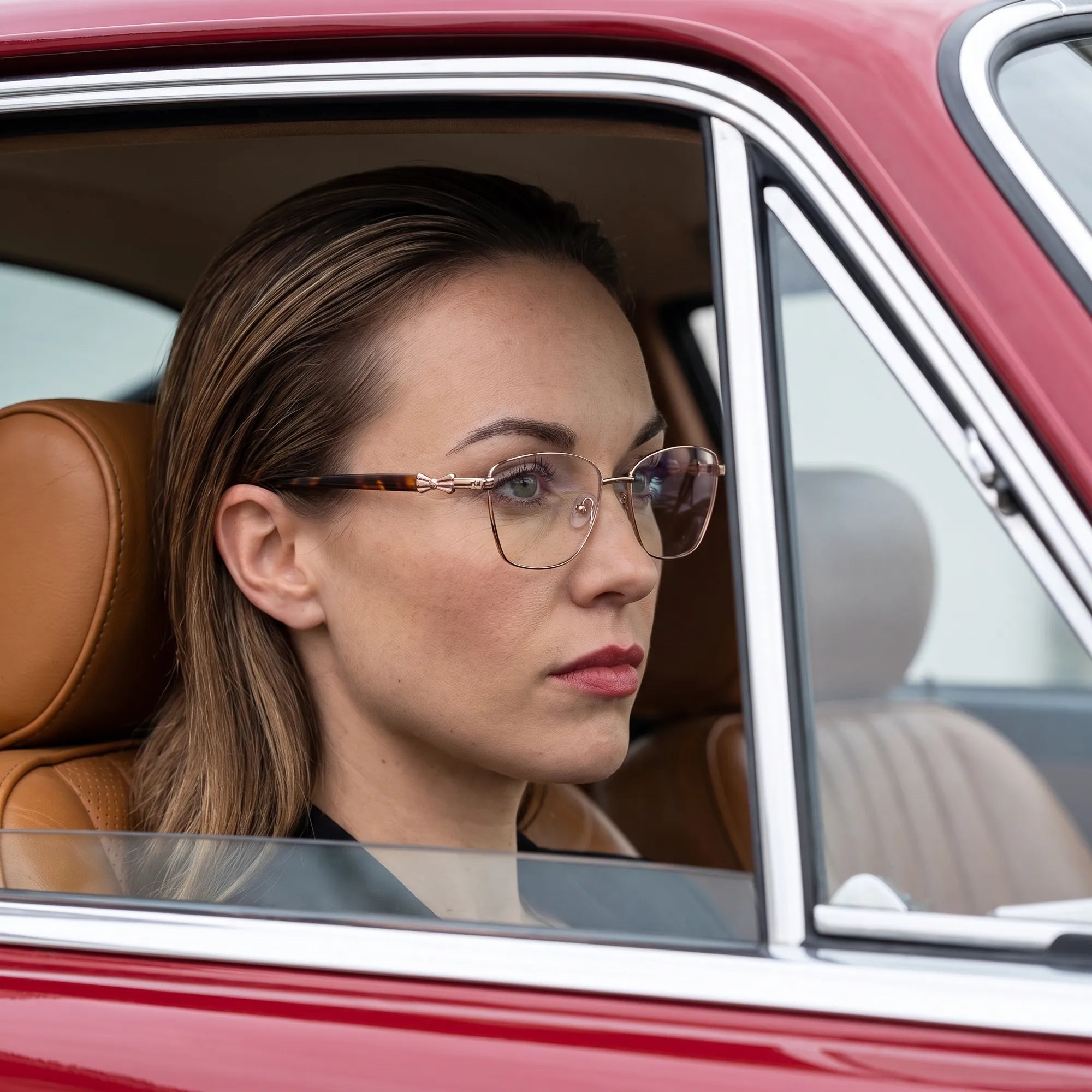 Fiore 22115 eyeglasses in brown, worn by a model – campaign portrait, gaze through a classic red car window