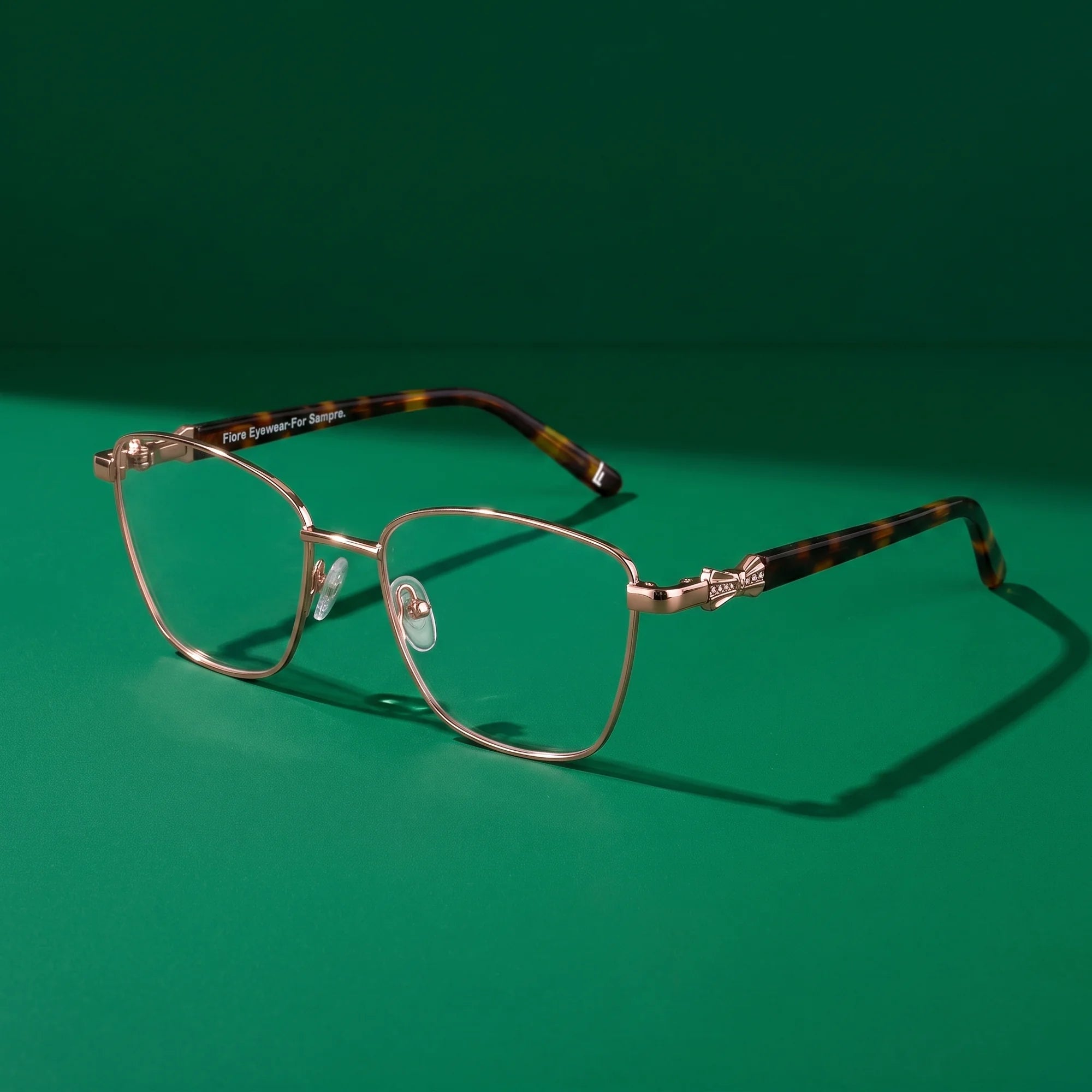 Fiore 22115 eyeglasses in brown – editorial still life on a saturated emerald set