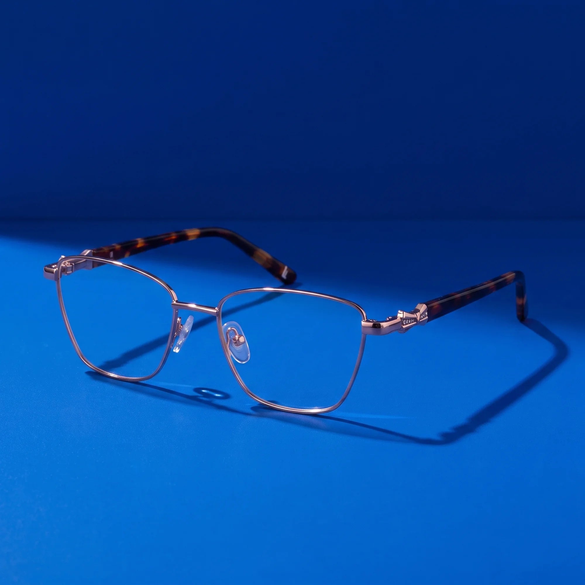 Fiore 22115 eyeglasses in brown – still life on a seamless cobalt studio backdrop