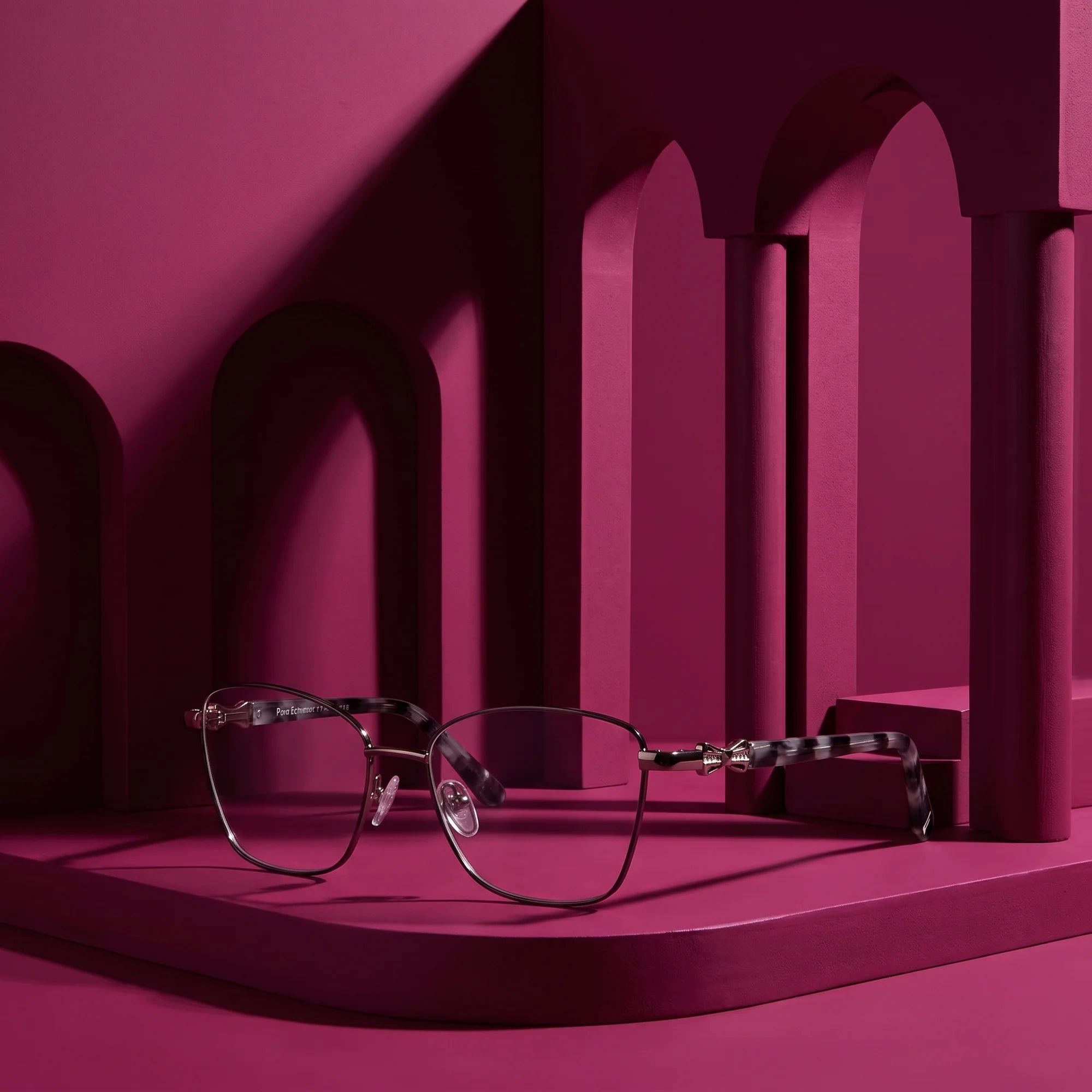 Fiore 22115 eyeglasses in black silver – staged on a sculptural magenta architecture set