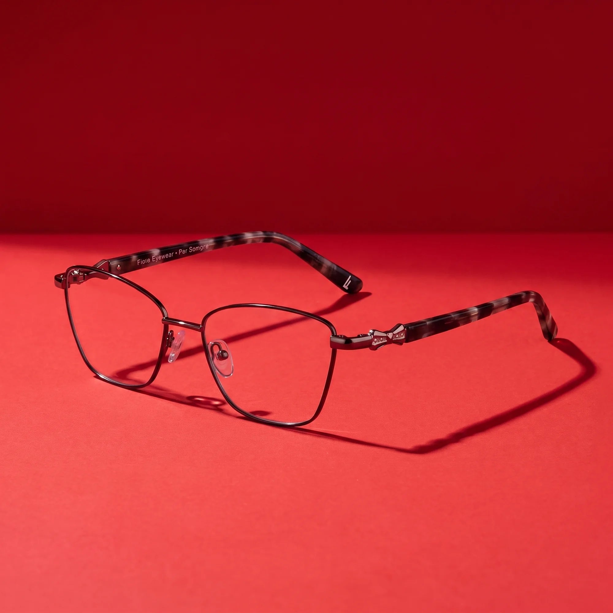 Fiore 22115 eyeglasses in black silver – editorial still life on a saturated vivid red set