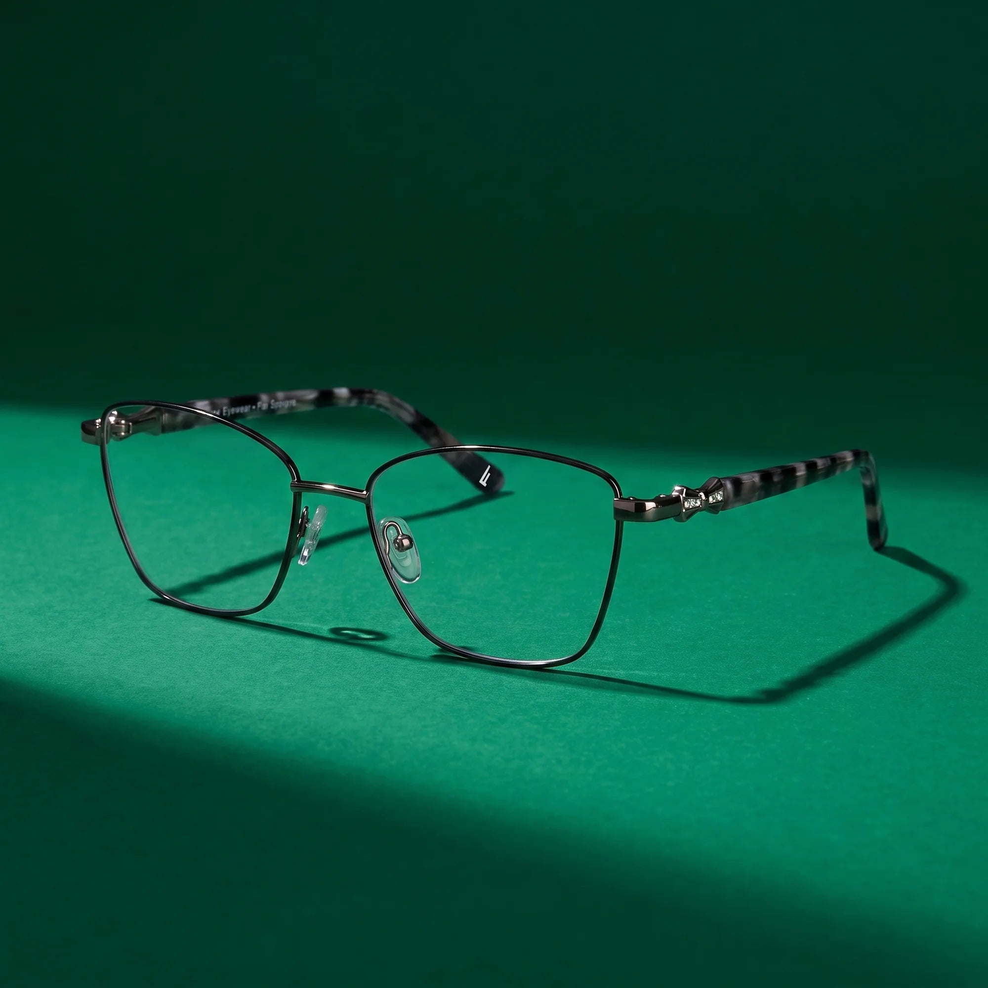 Fiore 22115 eyeglasses in black silver – still life on a seamless emerald studio backdrop