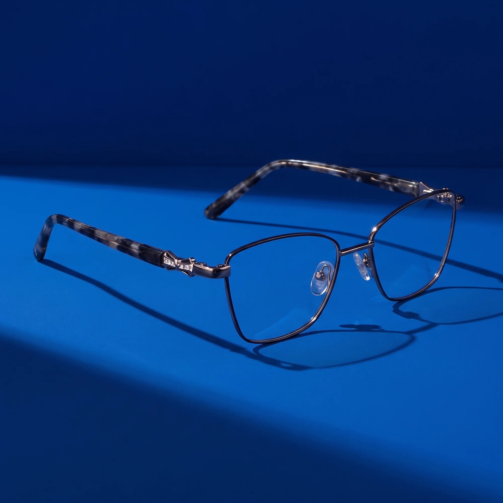 Fiore 22115 eyeglasses in black silver – hero still life against a deep cobalt backdrop