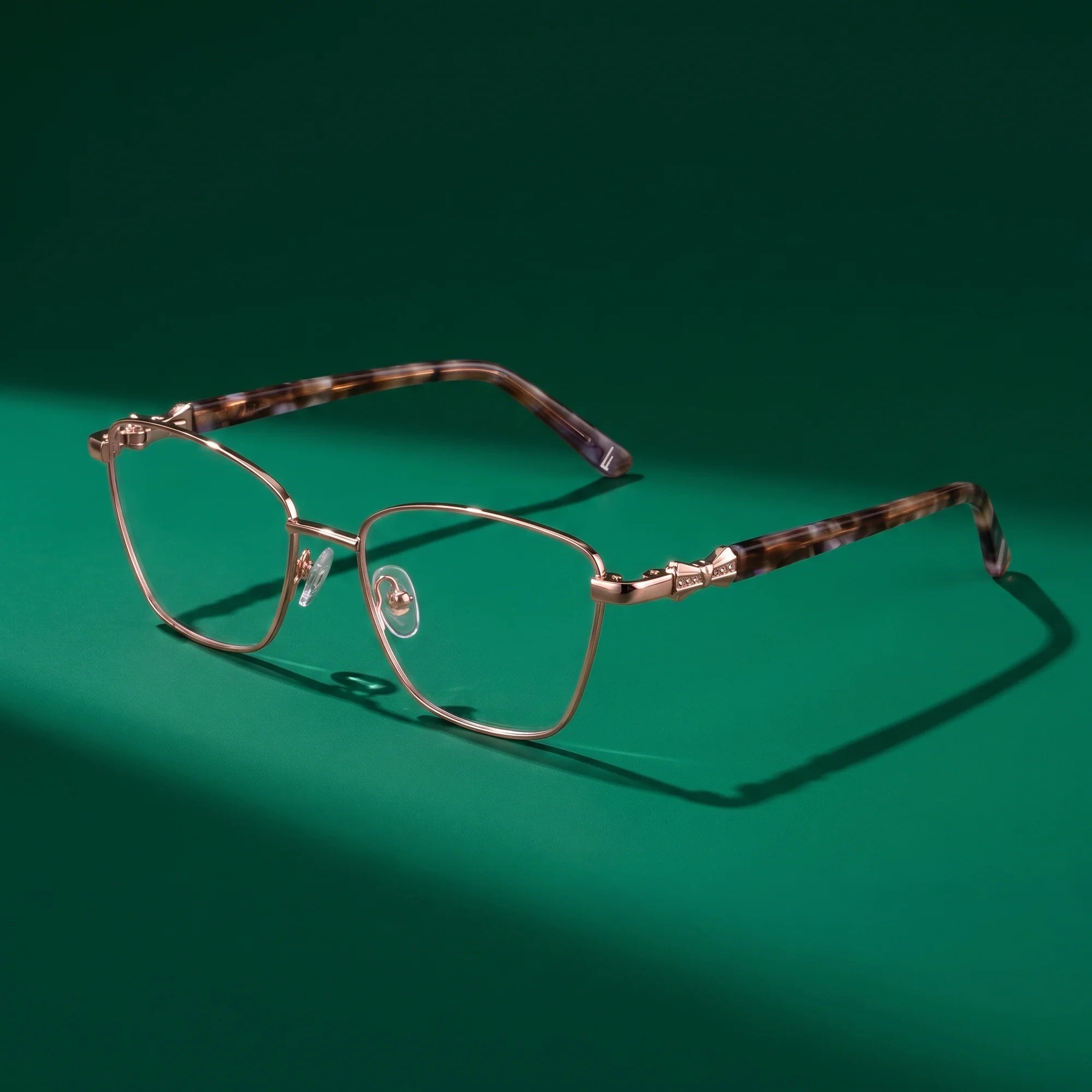 Fiore 22115 eyeglasses in gold – editorial still life on a saturated emerald set