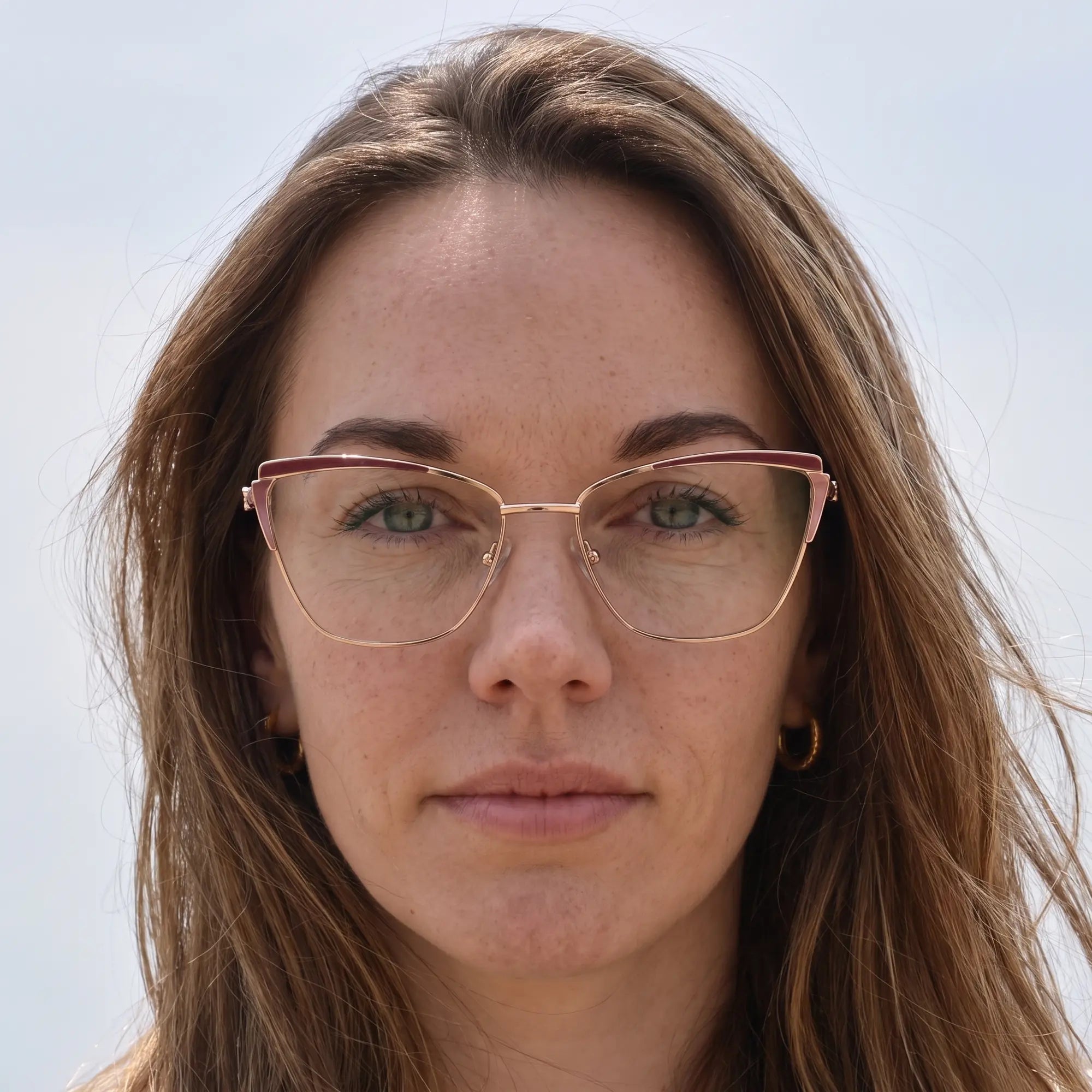Fiore 3837 eyeglasses in red gold, worn by a model – campaign portrait, floating together in milky summer water