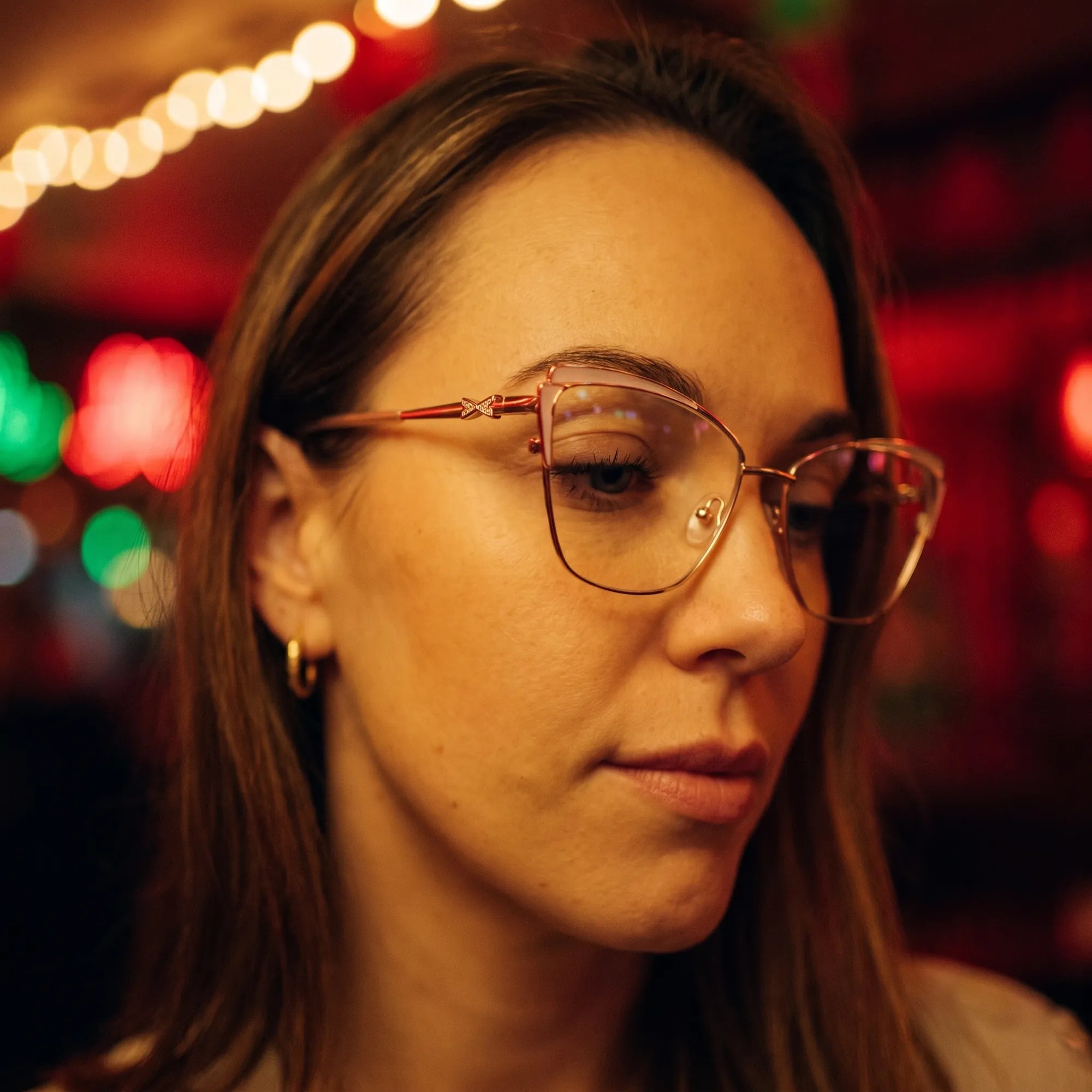 Fiore 3837 eyeglasses in pink gold, worn by a model – campaign portrait, candid portrait in neon-lit evening glow