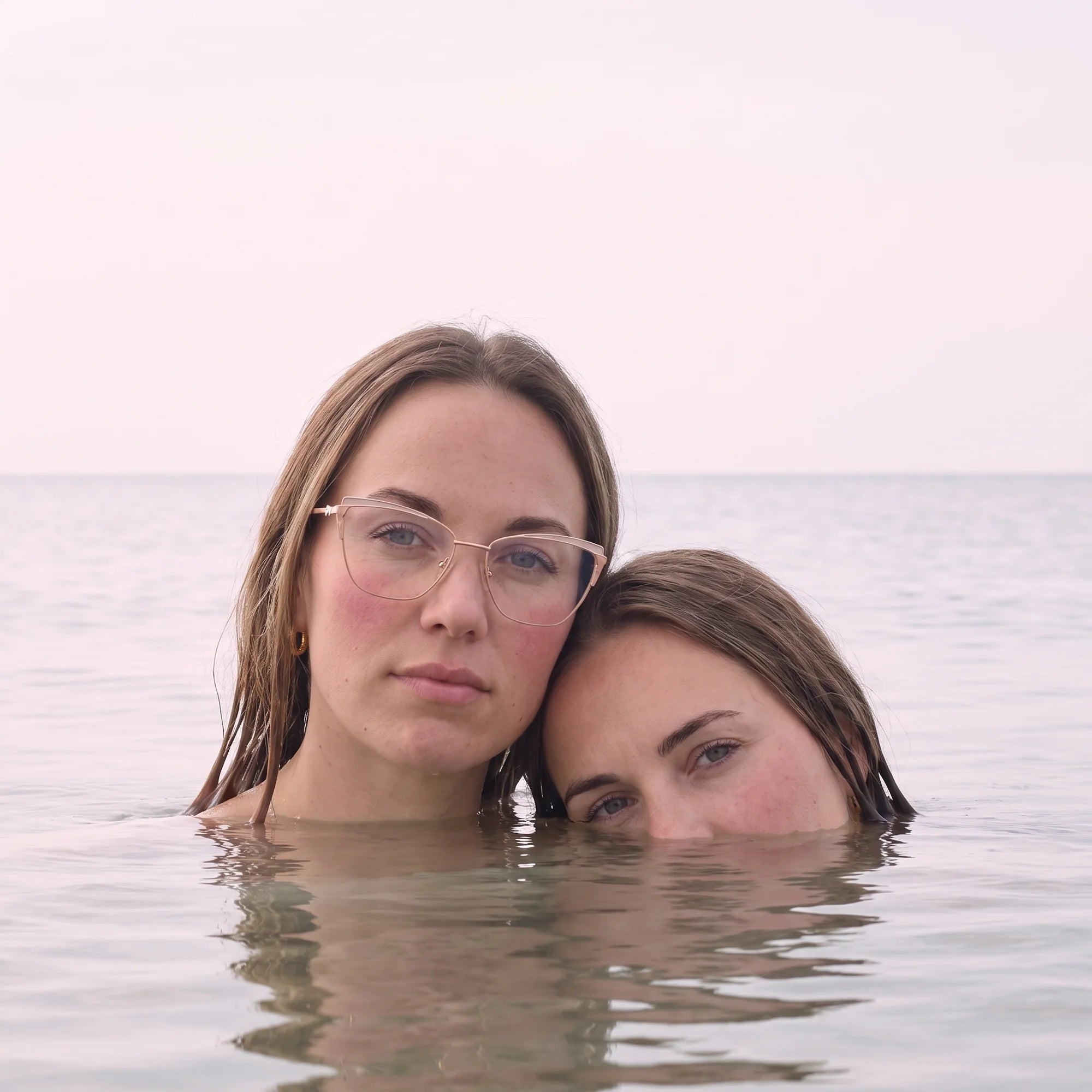 Fiore 3837 eyeglasses in pink gold, worn by a model – campaign portrait, wet-hair portrait in a calm summer sea