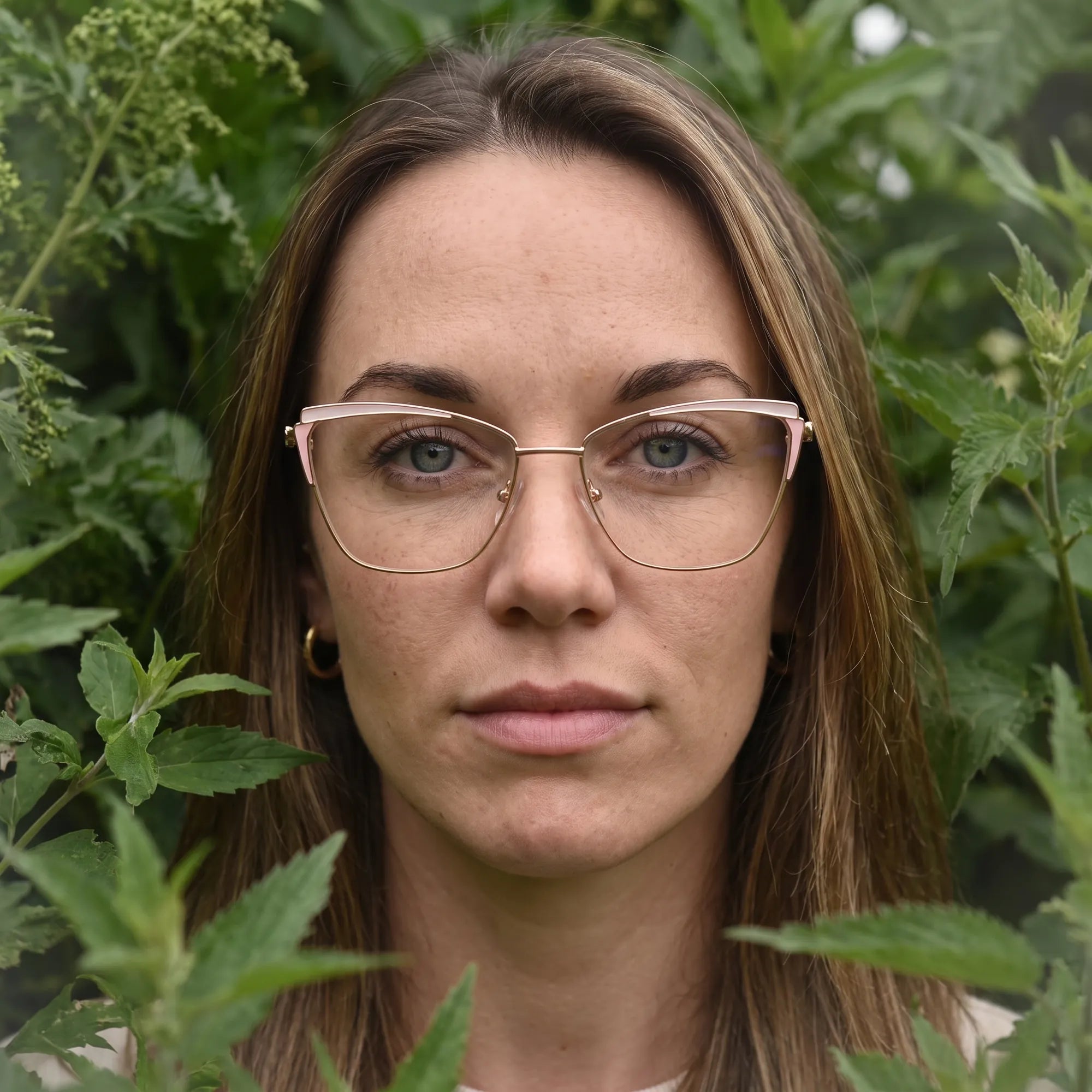Fiore 3837 eyeglasses in pink gold, worn by a model – campaign portrait, summer daydream in a garden armchair
