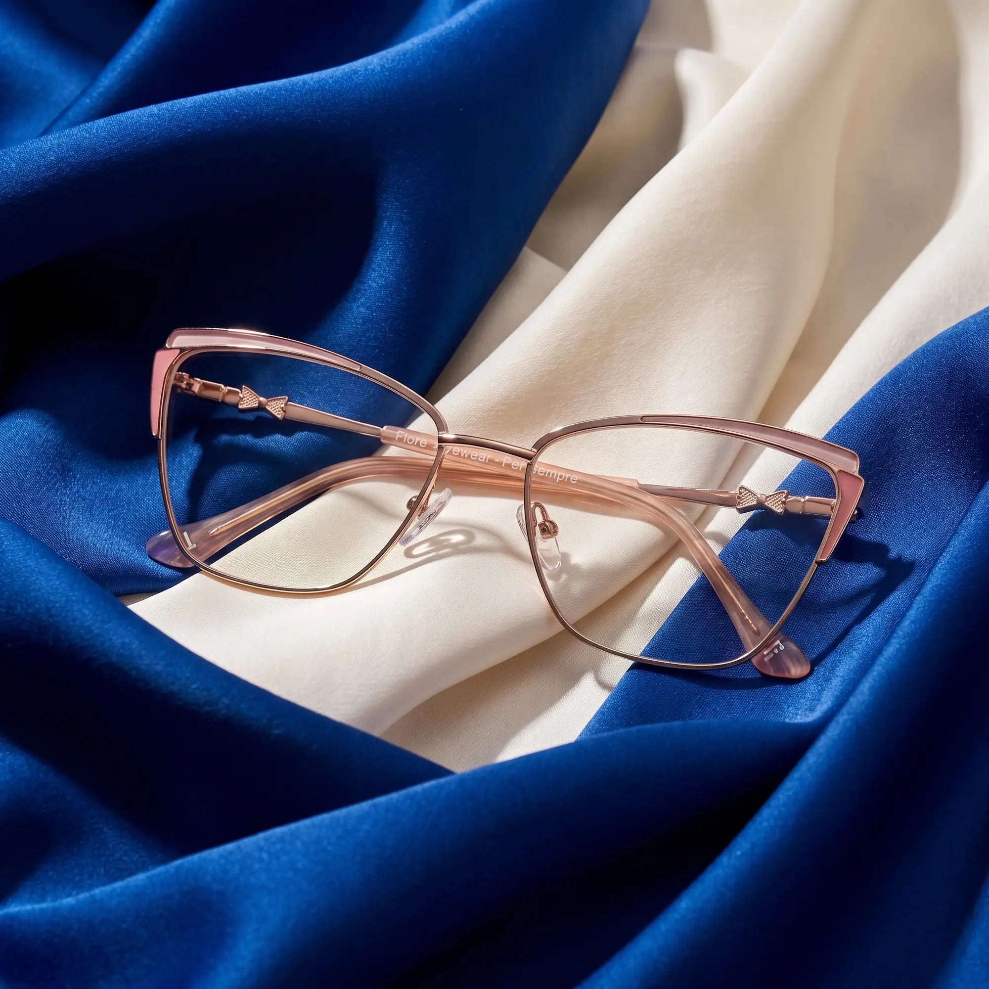Fiore 3837 eyeglasses in pink gold – resting on draped cobalt and ivory silk