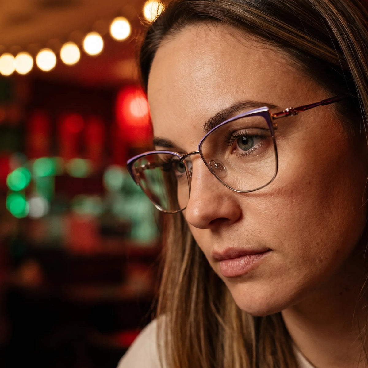 Fiore 3839 eyeglasses in purple silver, worn by a model – campaign portrait, candid portrait in neon-lit evening glow