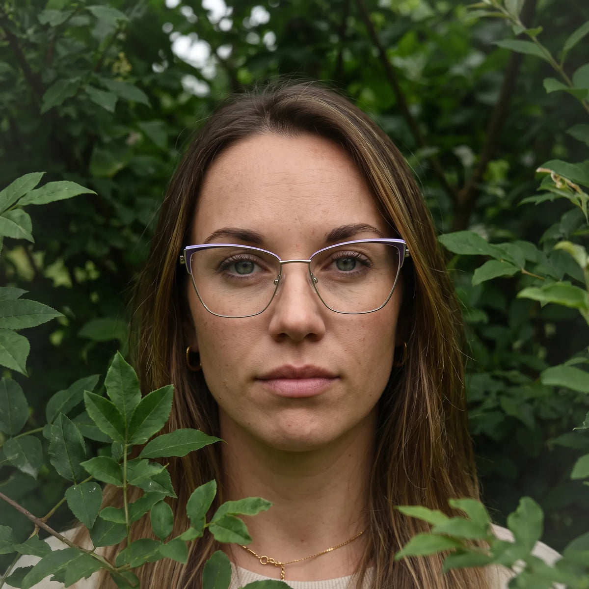 Fiore 3839 eyeglasses in purple silver, worn by a model – campaign portrait, summer daydream in a garden armchair