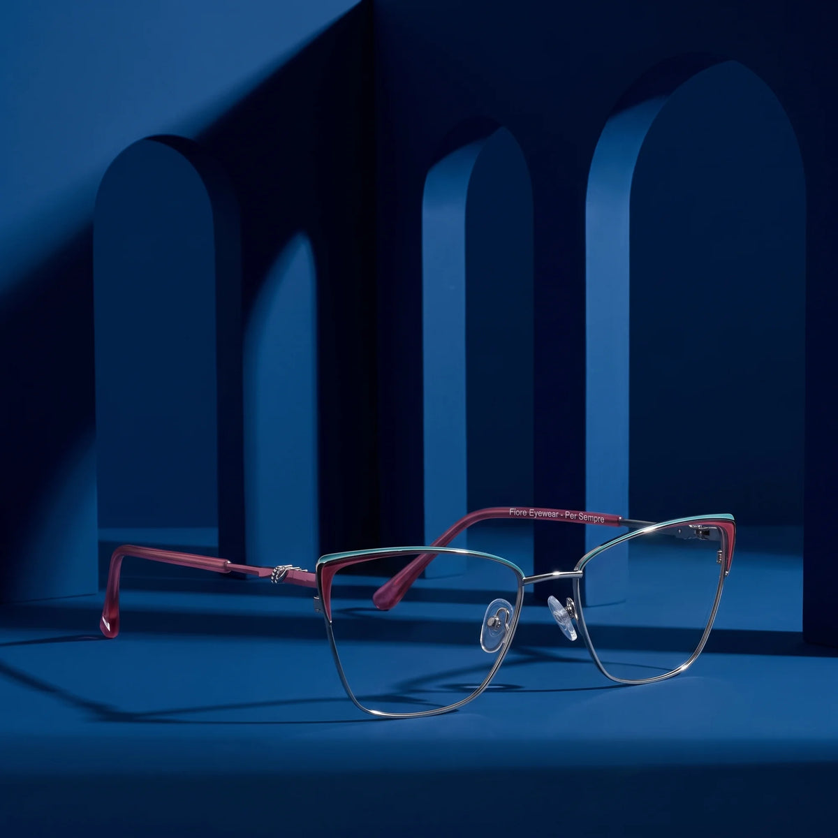Fiore 3839 eyeglasses in red gun – staged on a sculptural midnight blue architecture set