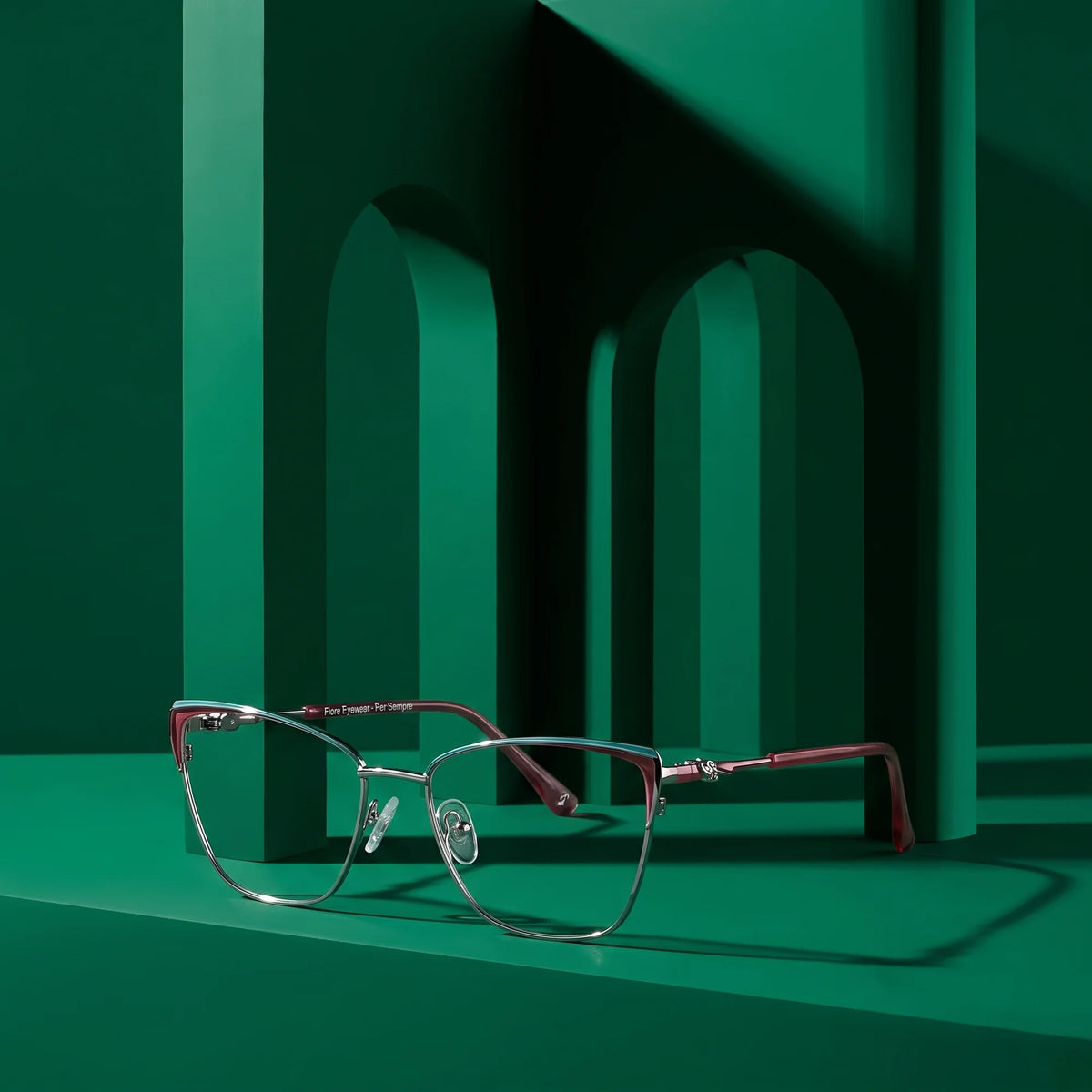 Fiore 3839 eyeglasses in red gun – displayed on a emerald podium among arches