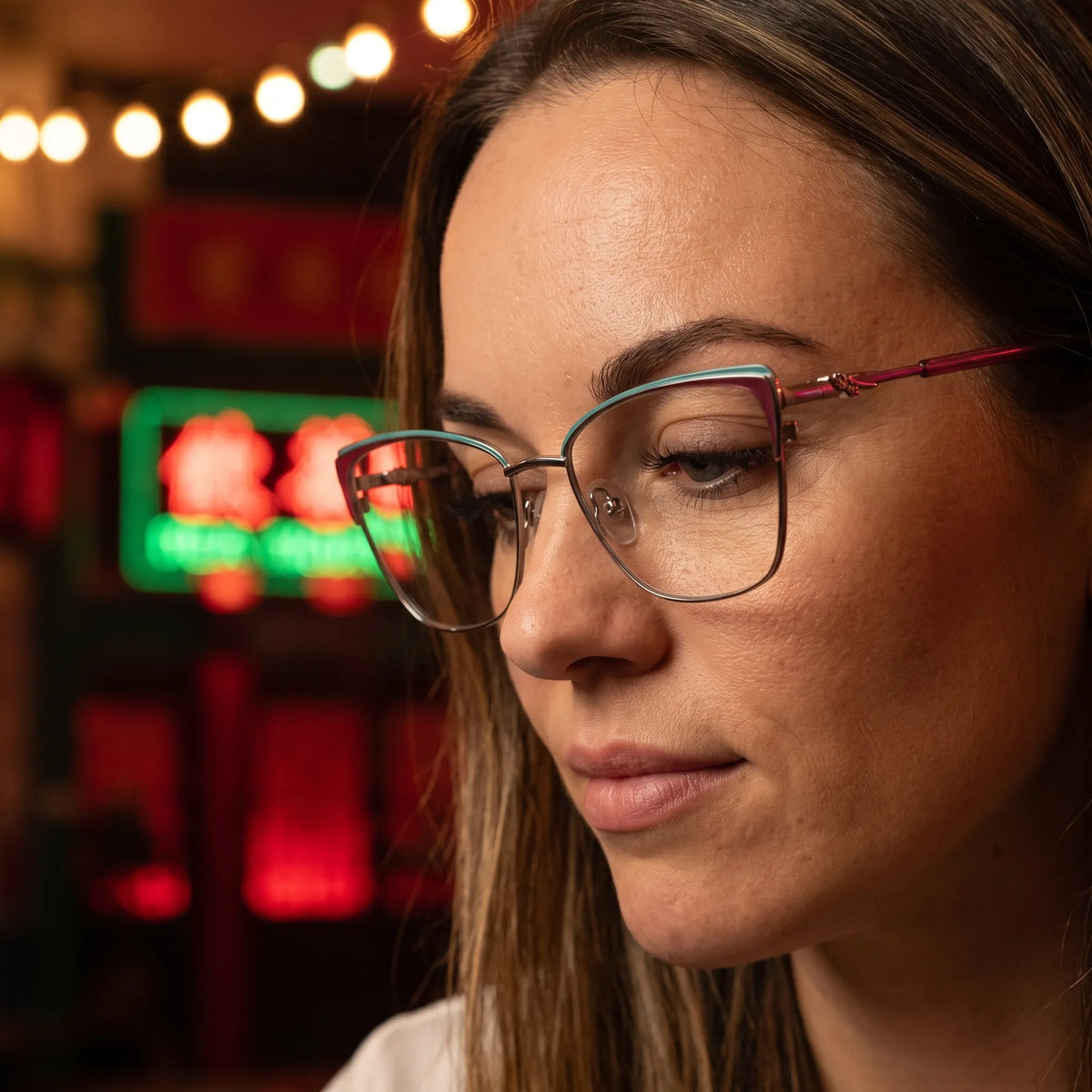 Fiore 3839 eyeglasses in red gun, worn by a model – campaign portrait, candid portrait in neon-lit evening glow
