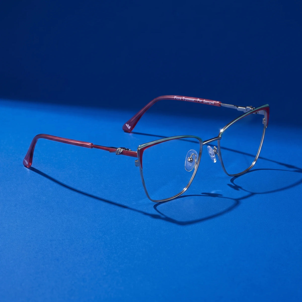 Fiore 3839 eyeglasses in red gun – editorial still life on a saturated cobalt set