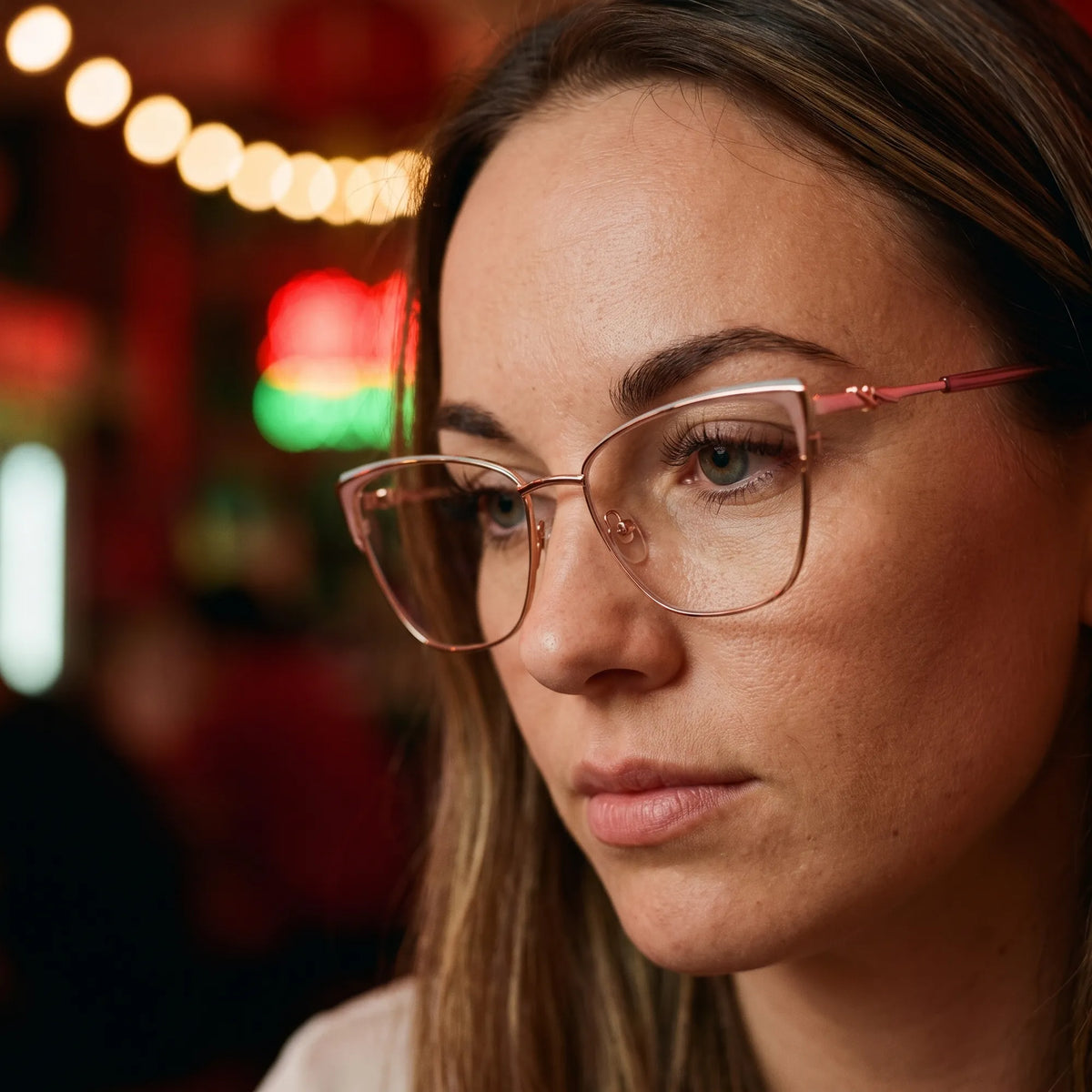 Fiore 3839 eyeglasses in pink gold, worn by a model – campaign portrait, candid portrait in neon-lit evening glow