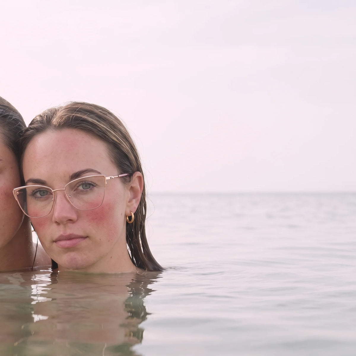 Fiore 3839 eyeglasses in pink gold, worn by a model – campaign portrait, wet-hair portrait in a calm summer sea