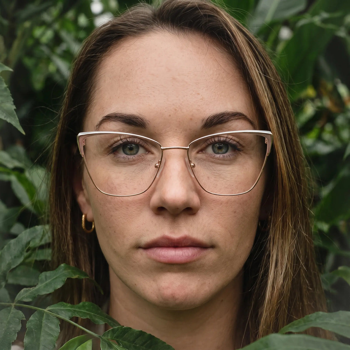 Fiore 3839 eyeglasses in pink gold, worn by a model – campaign portrait, summer daydream in a garden armchair