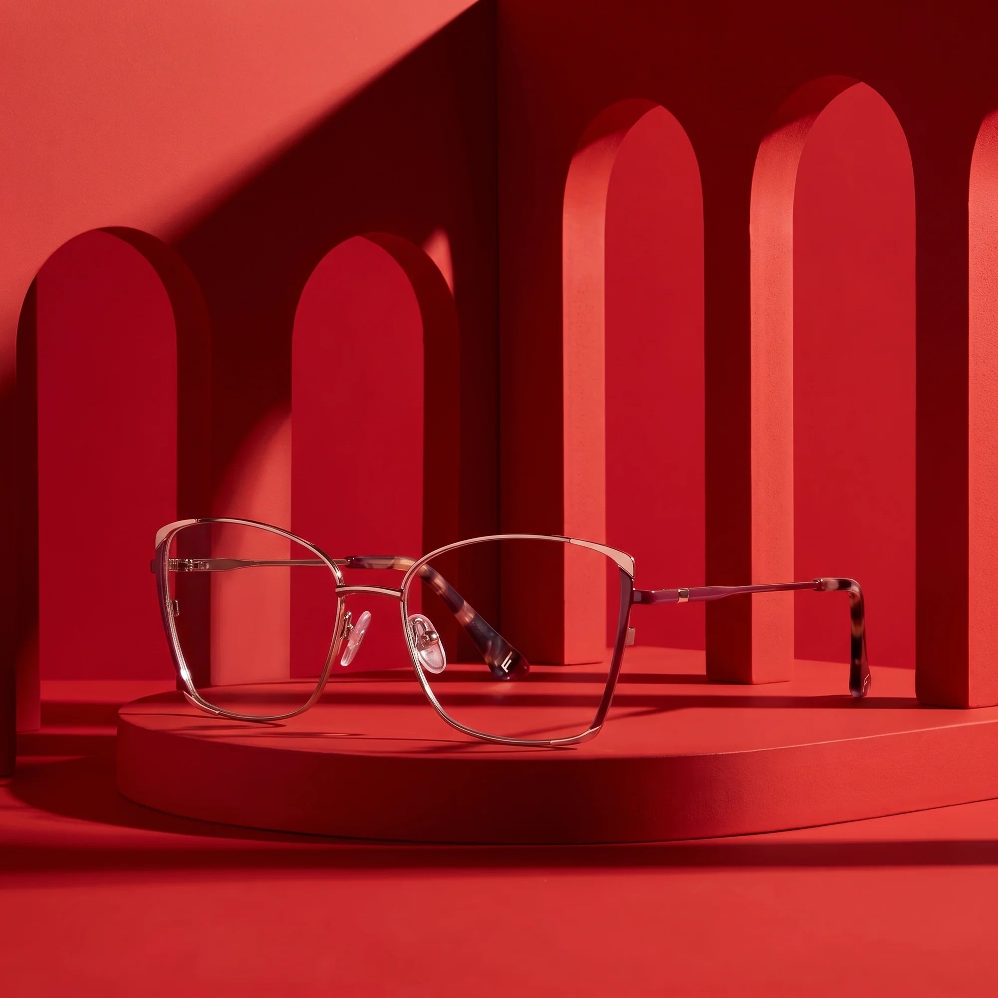Fiore 3916 eyeglasses in purple pink silver – staged on a sculptural vivid red architecture set