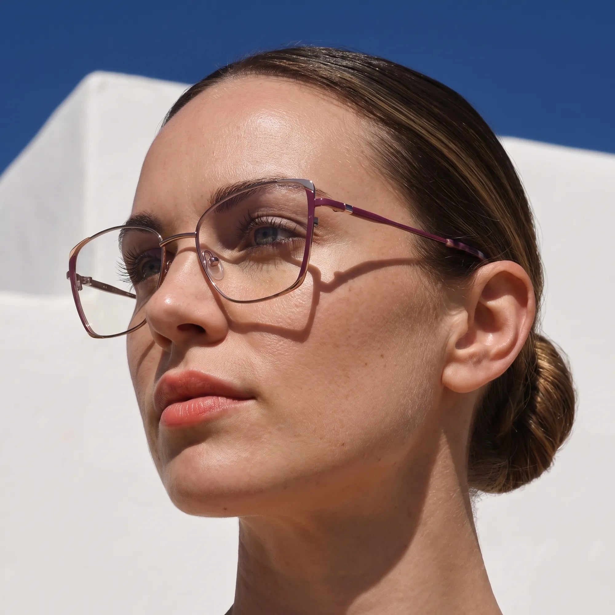 Fiore 3916 eyeglasses in purple pink silver, worn by a model – campaign portrait, sunlit Balearic whitewash and deep blue sky