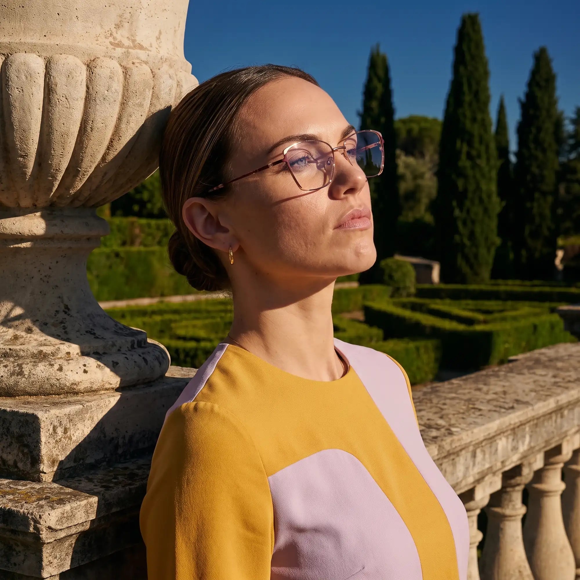 Fiore 3916 eyeglasses in purple pink silver, worn by a model – campaign portrait, dusk light over a cypress garden