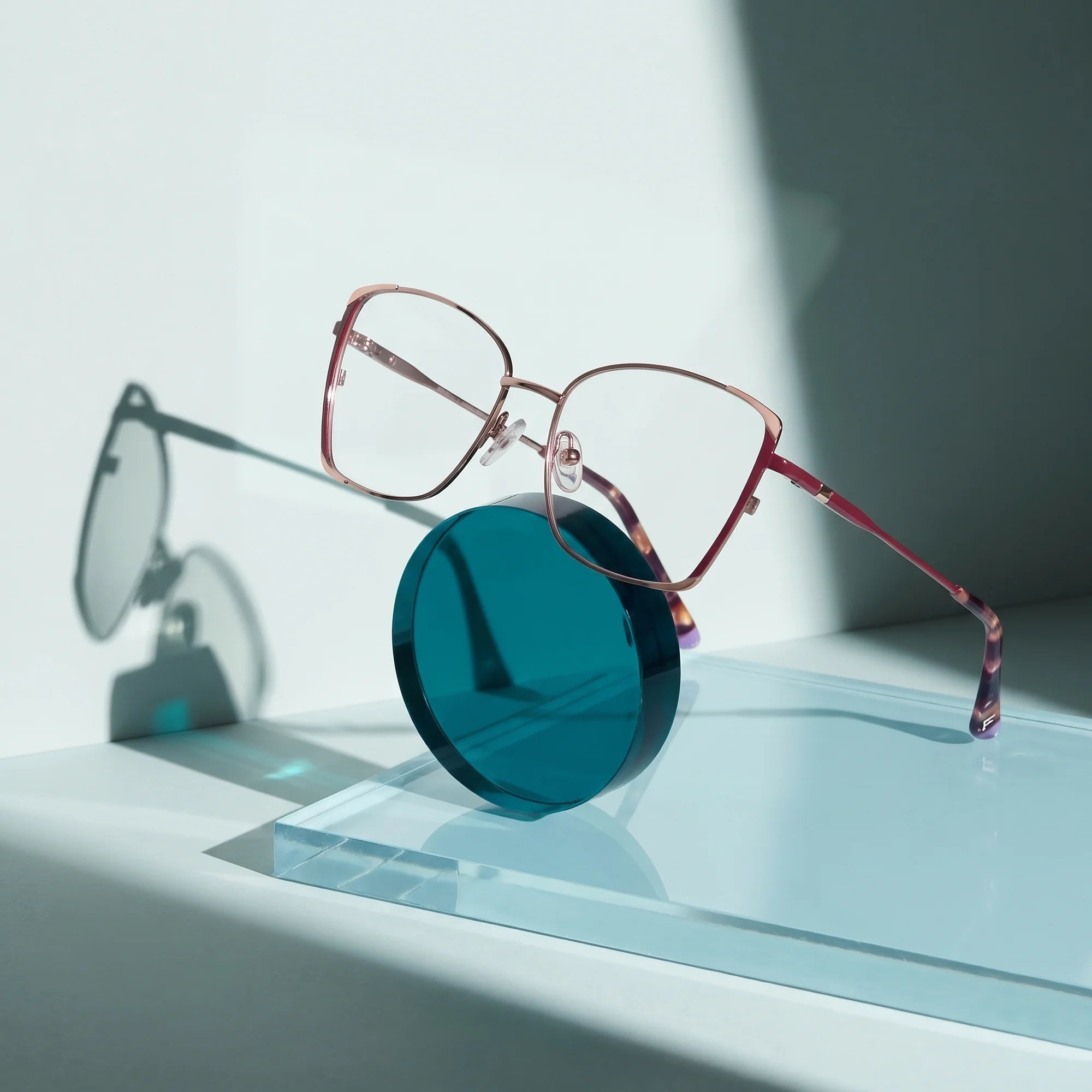 Fiore 3916 eyeglasses in purple pink silver – on a cobalt acrylic disc in soft daylight