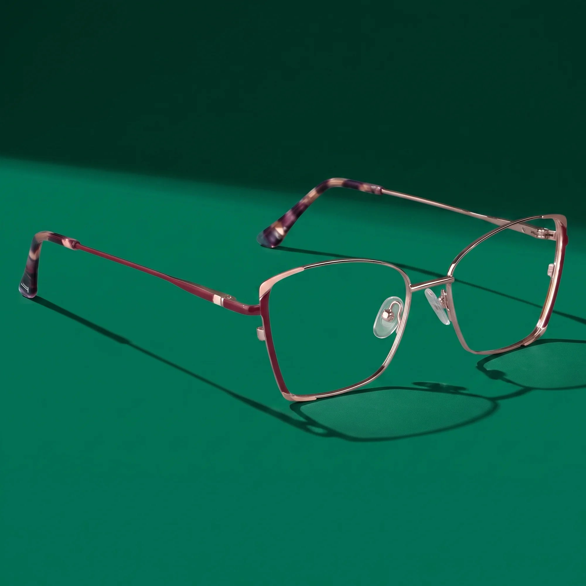 Fiore 3916 eyeglasses in purple pink silver – editorial still life on a saturated emerald set