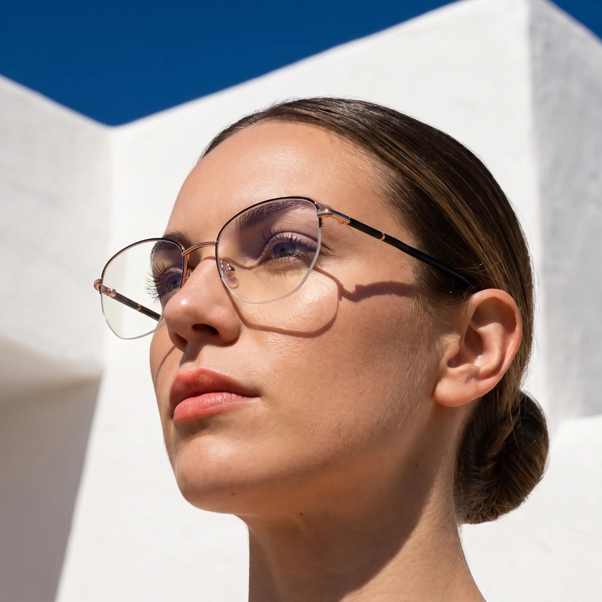 Fiore 3921 eyeglasses in black gold, worn by a model – campaign portrait, sunlit Balearic whitewash and deep blue sky