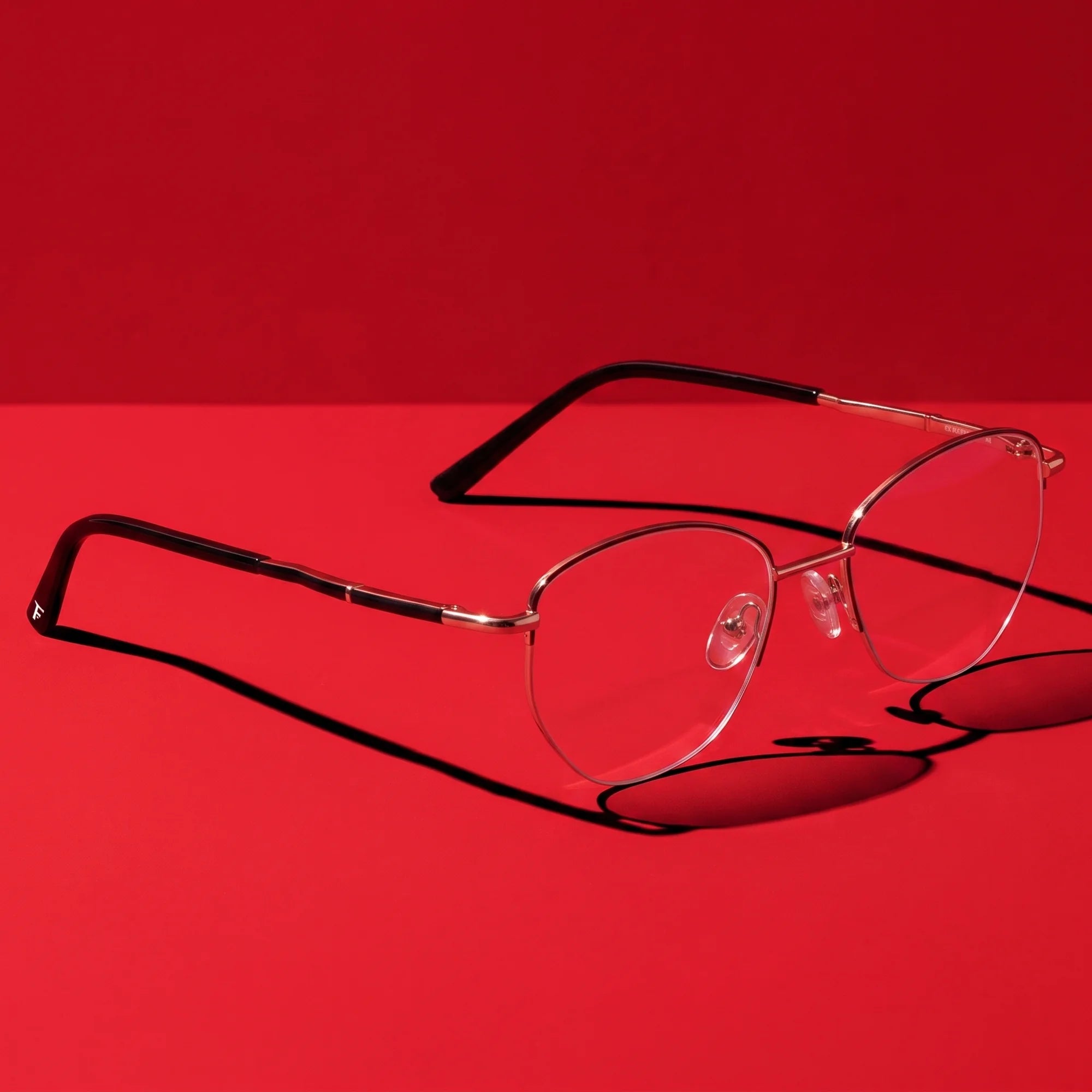 Fiore 3921 eyeglasses in black gold – editorial still life on a saturated vivid red set