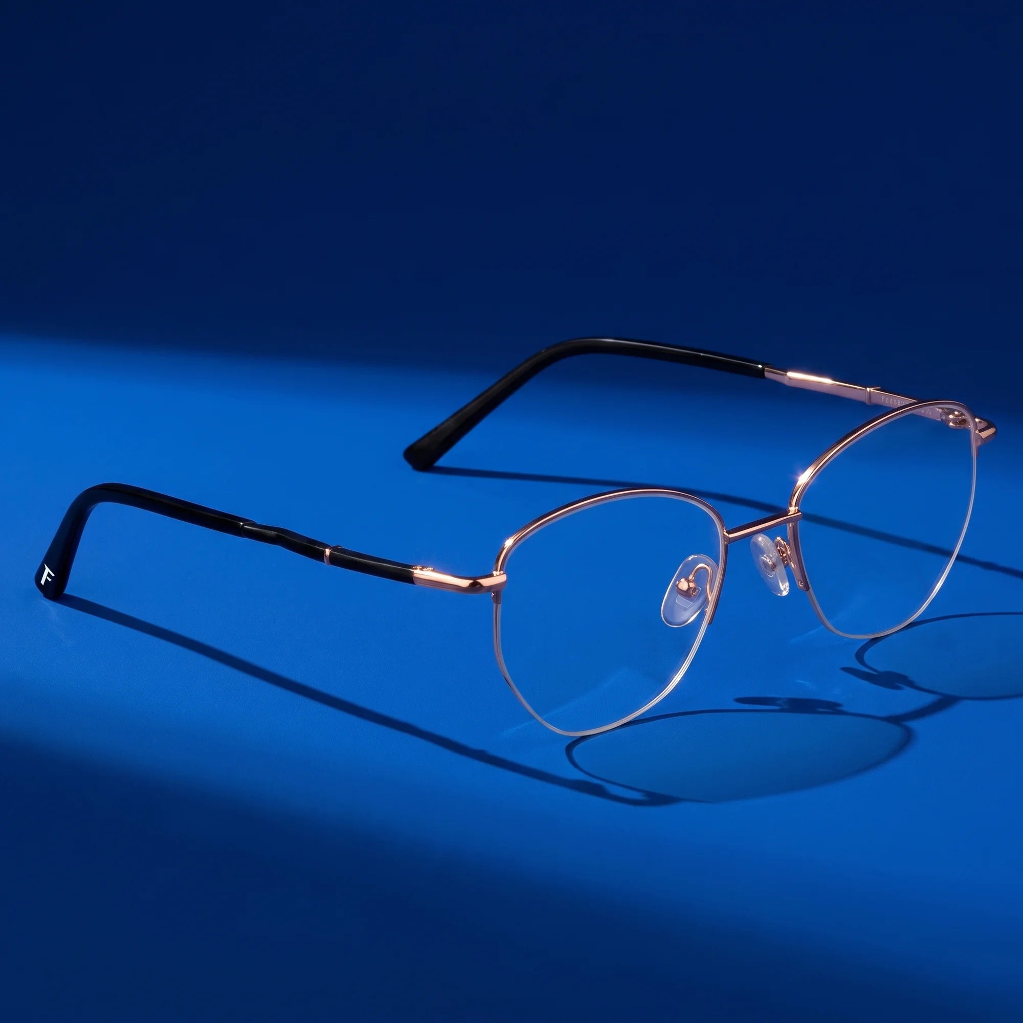 Fiore 3921 eyeglasses in black gold – hero still life against a deep cobalt backdrop