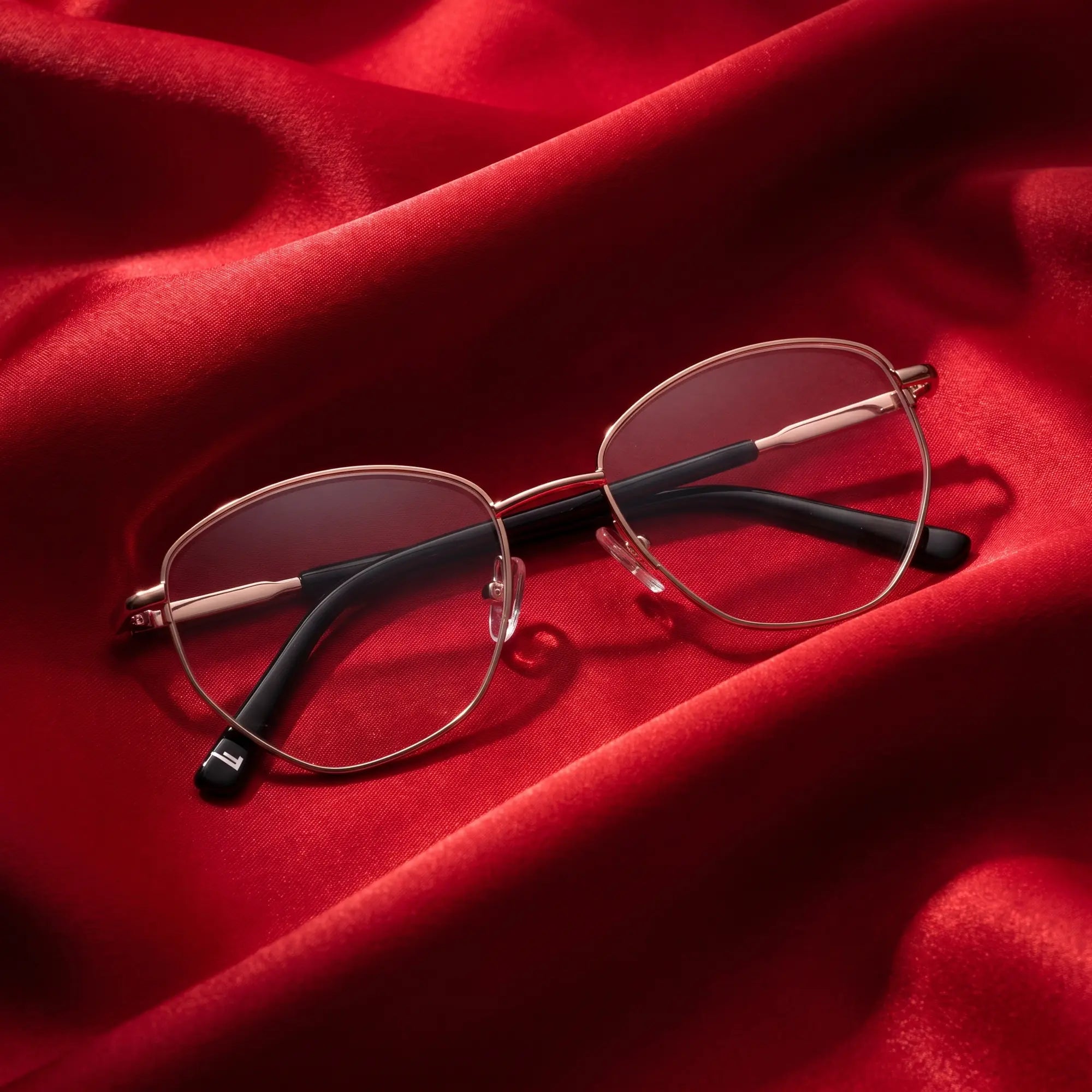 Fiore 3921 eyeglasses in black gold – nested in flowing vivid red silk