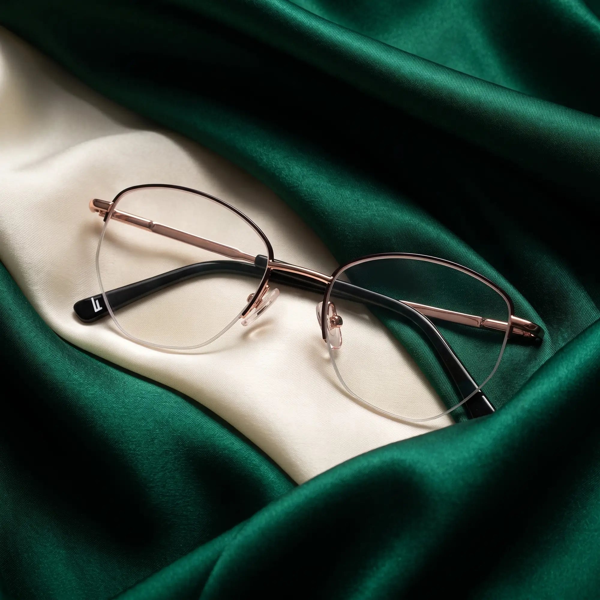 Fiore 3921 eyeglasses in black gold – resting on draped emerald and ivory silk